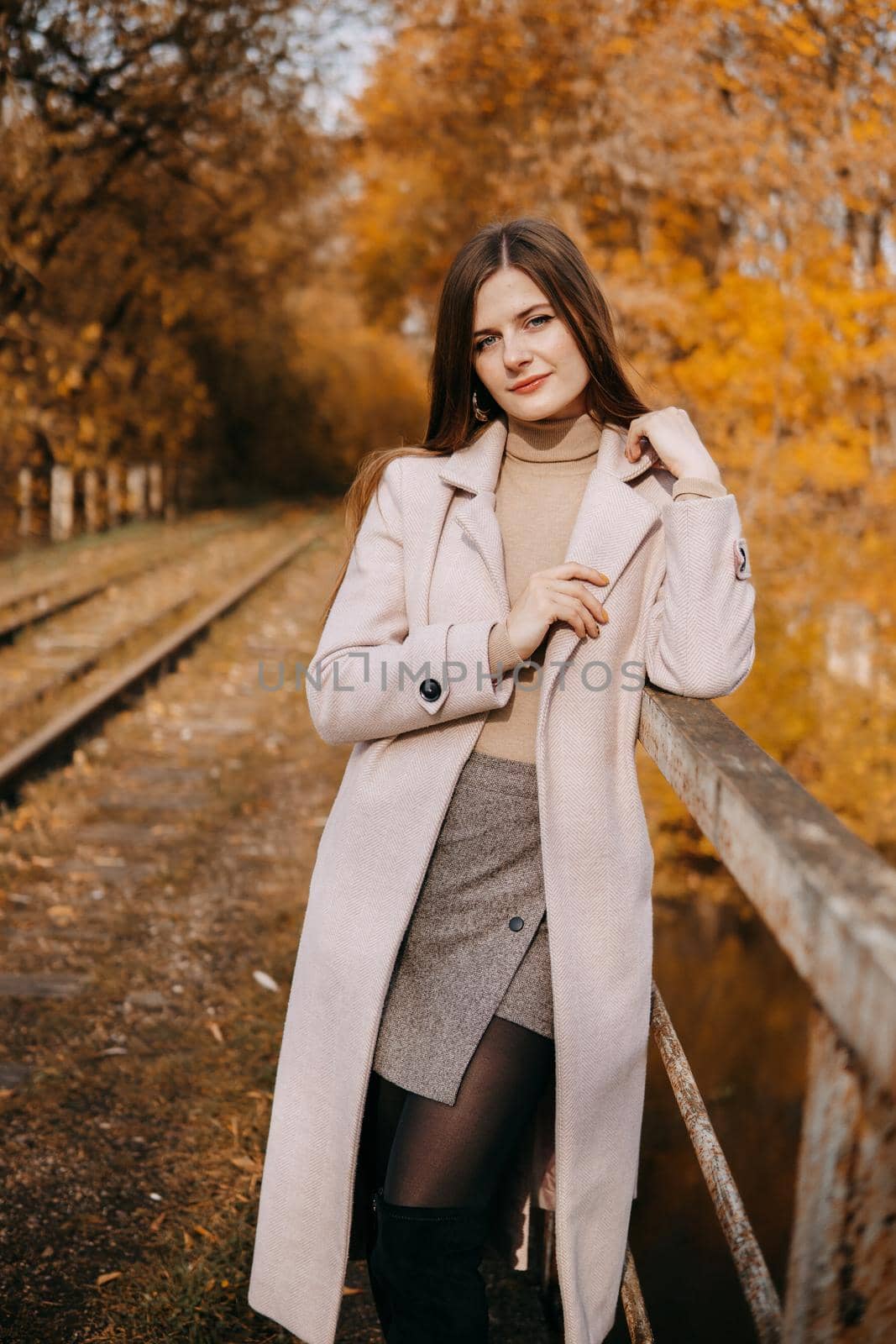 beautiful long-haired woman walks through the autumn streets. Railway, autumn, woman in a coat. by Annu1tochka