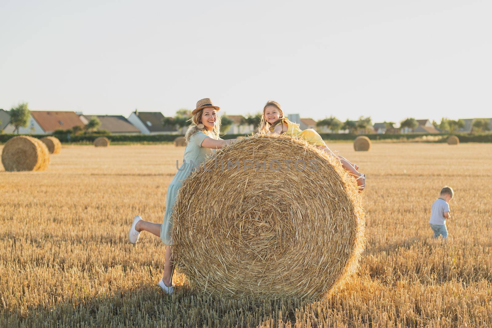 Mother and children near bales of wheat Countryside