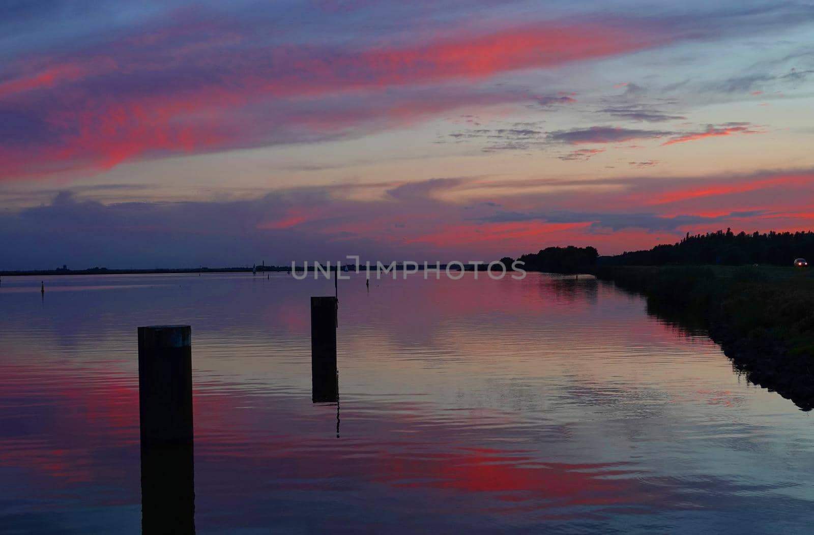 Dramatic sunset reflected in the water of the Veluwemeer, Netherlands