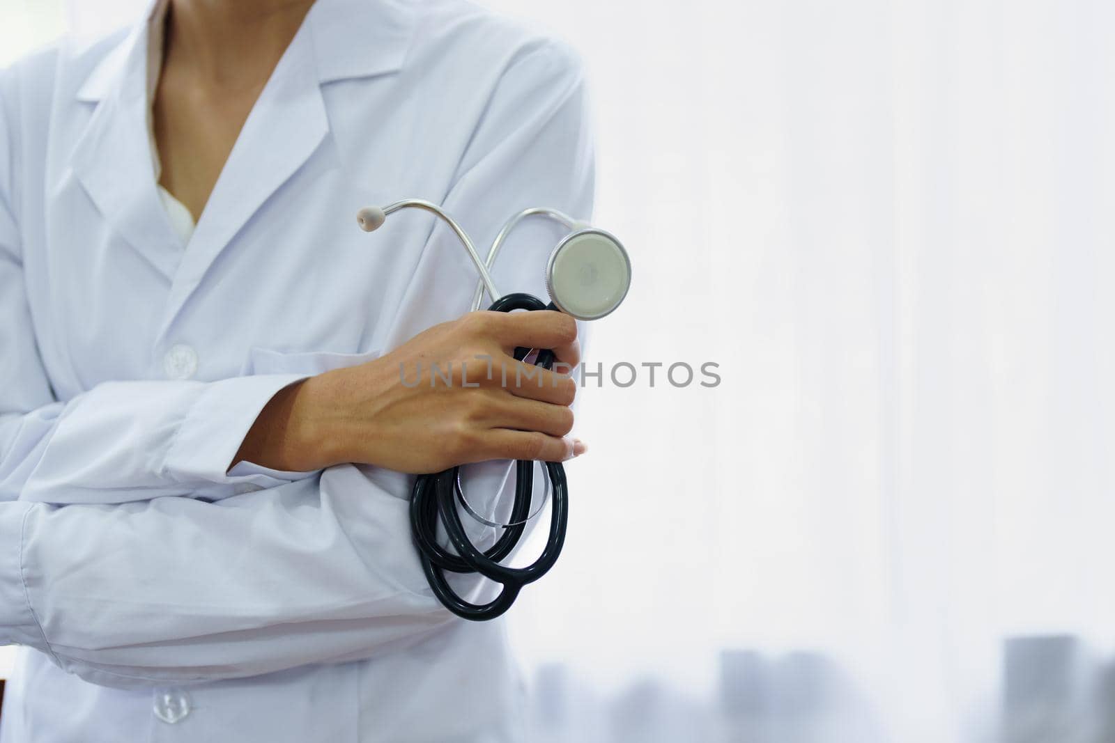 Portrait of an Asian female doctor smiling happily holding a stethoscope after a break from work.