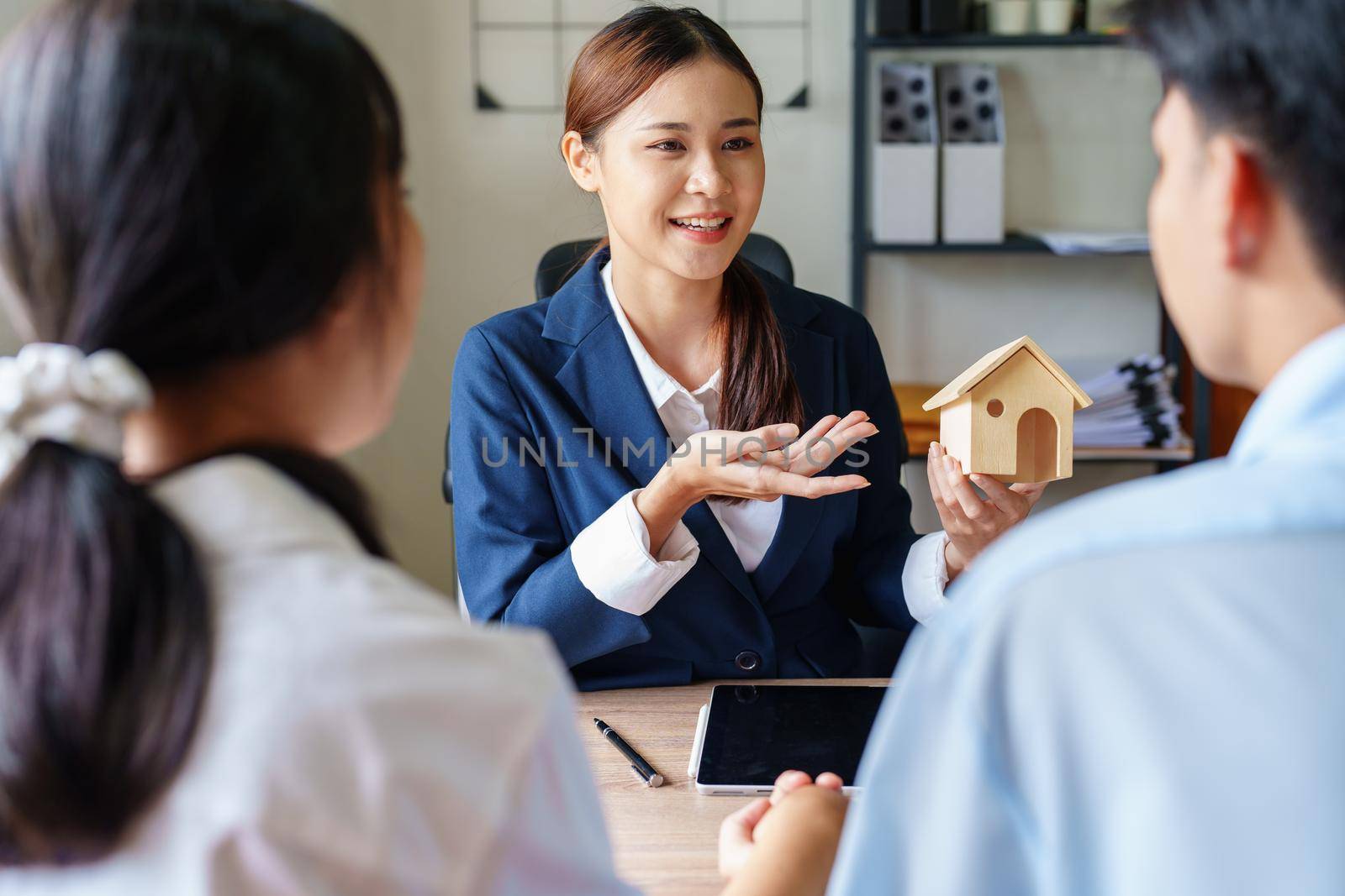 Portrait of a real estate agent or bank officer, the lending department quotes the interest on the loan to the customer to assess the risk of investing in a home by Manastrong