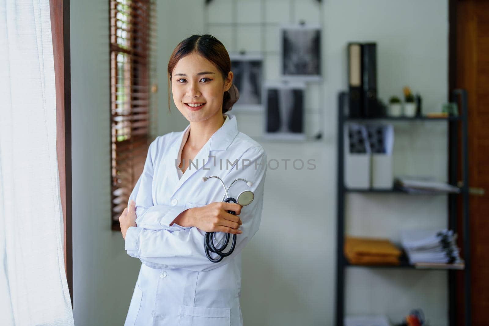 Portrait of an Asian female doctor smiling happily holding a stethoscope after a break from work.