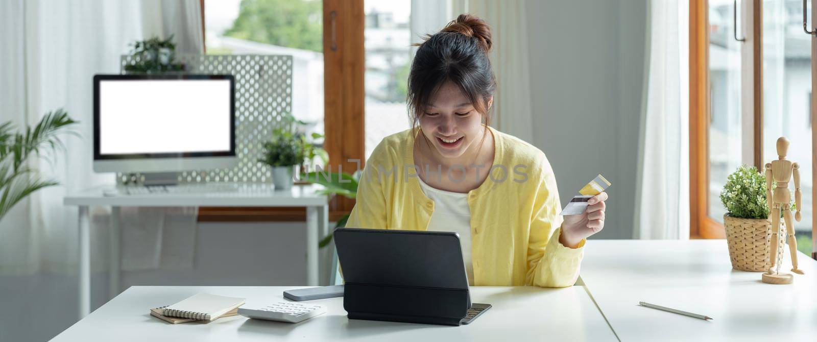 Close up of girl hold bank credit card, shopping online using laptop computer, buying goods or ordering online, entering bank accounts and details in online banking offer