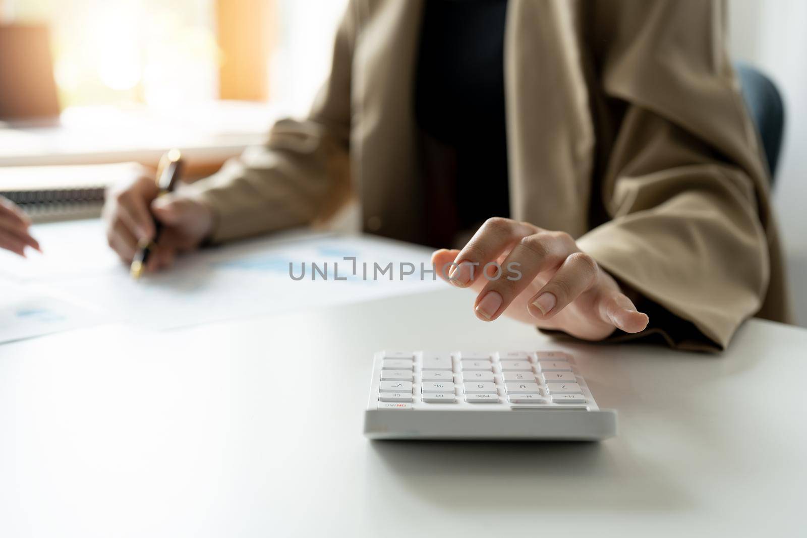 Close up bookkeeper woman working about financial with calculator at her office to calculate expenses, Accounting concept.