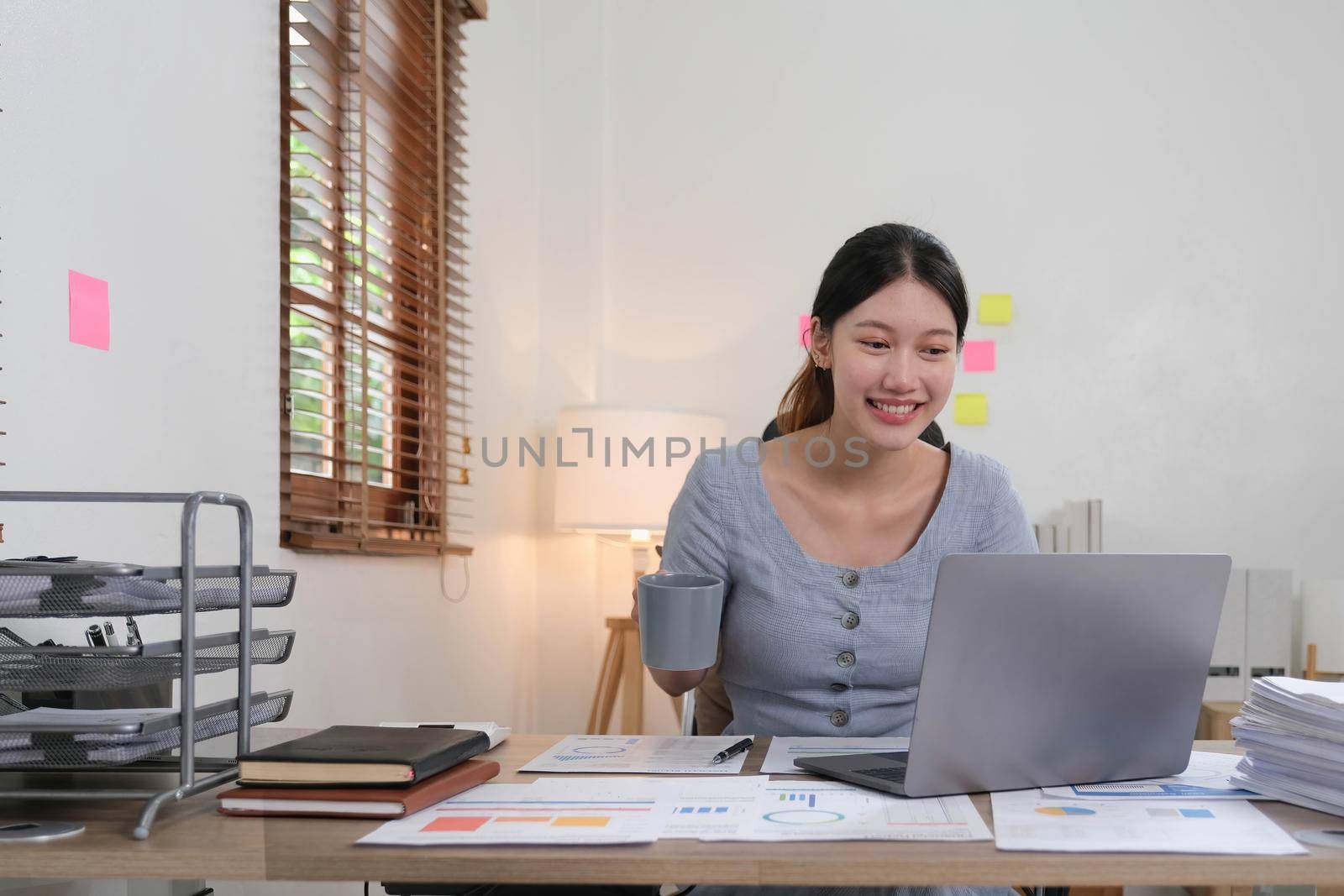 Portrait of Young woman using laptop computer at the office, Student girl working at home. Work or study from home, Asian woman freelance, business, lifestyle concept.