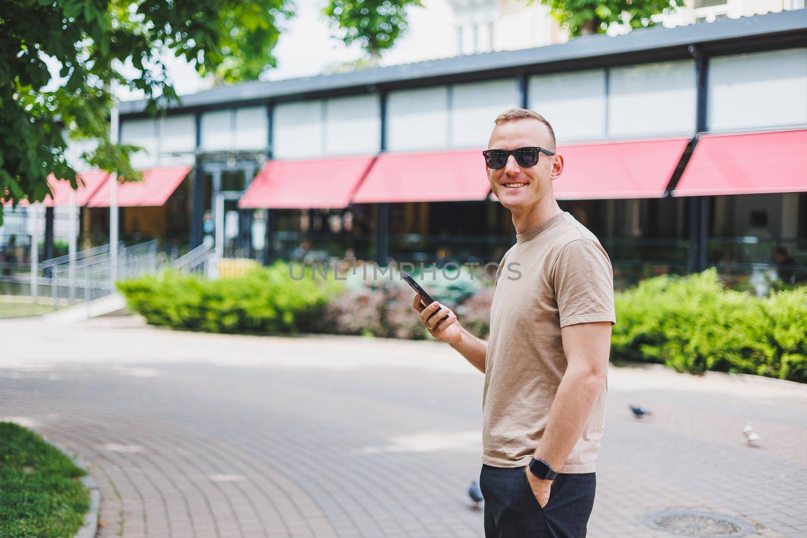 Man in shopping. Smiling man with shopping bags walking down the street. Consumerism, lifestyle concept