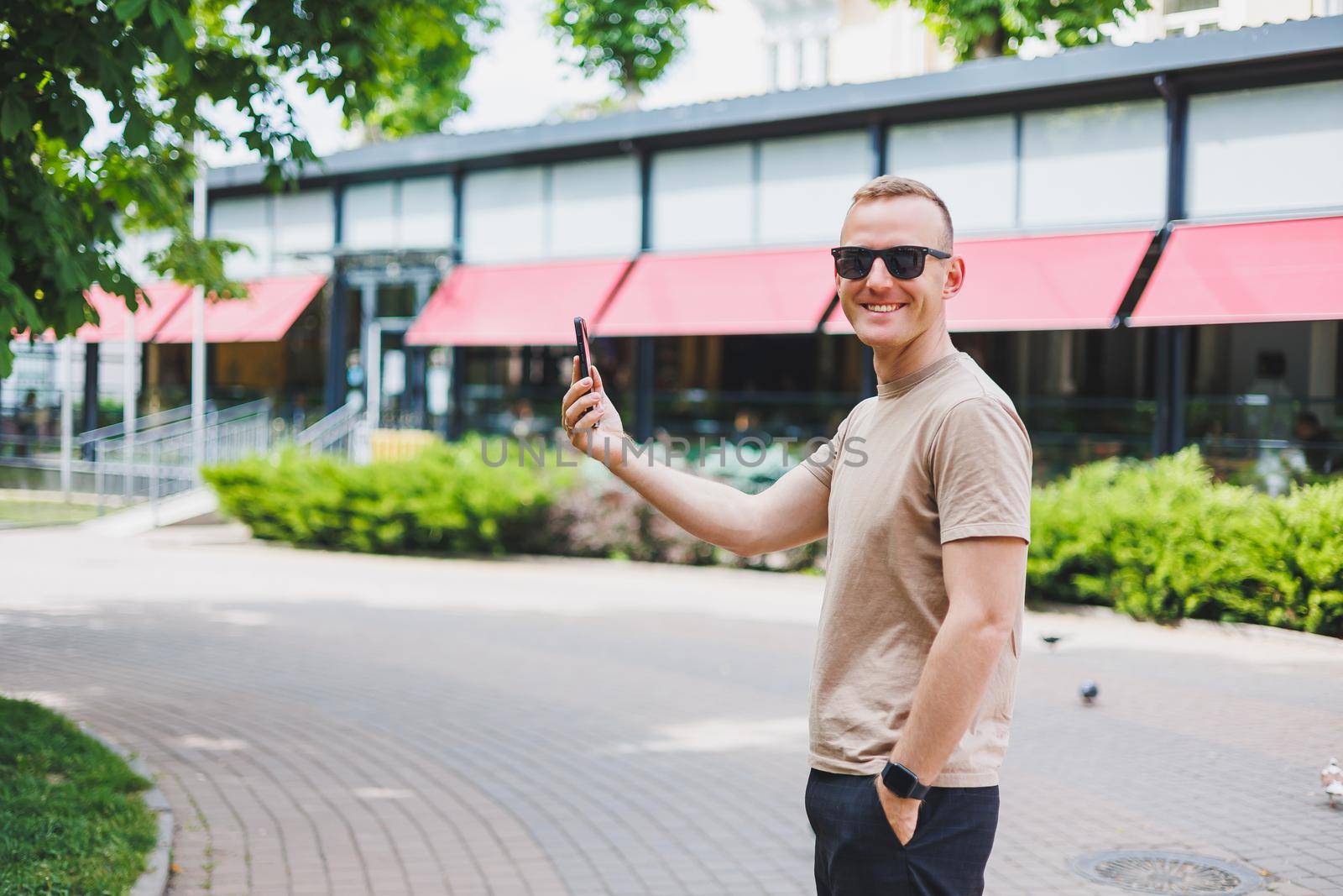 Man in shopping. Smiling man with shopping bags walking down the street. Consumerism, lifestyle concept