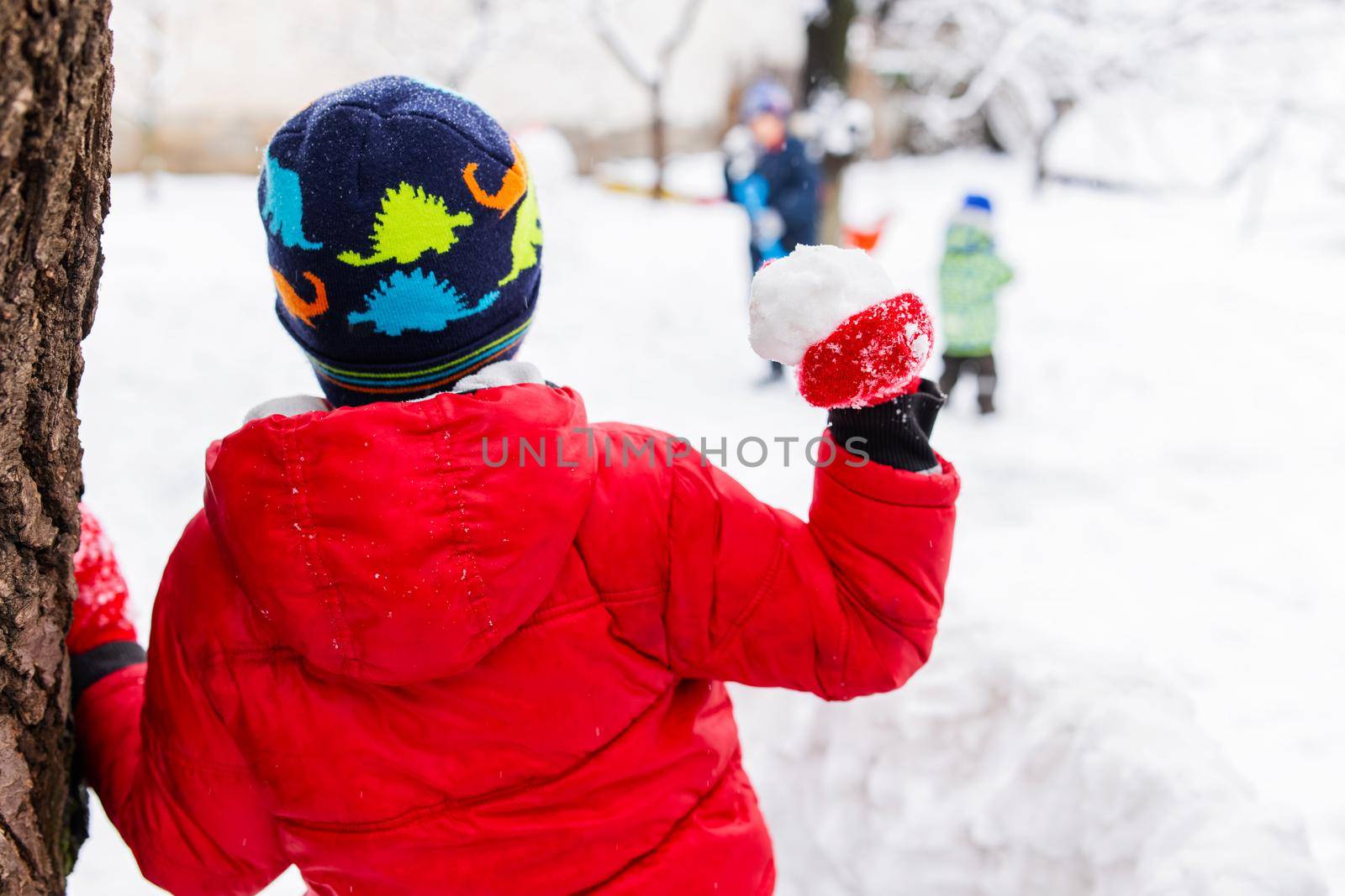 Little children playing with snowballs outdoor in the park by andreyz