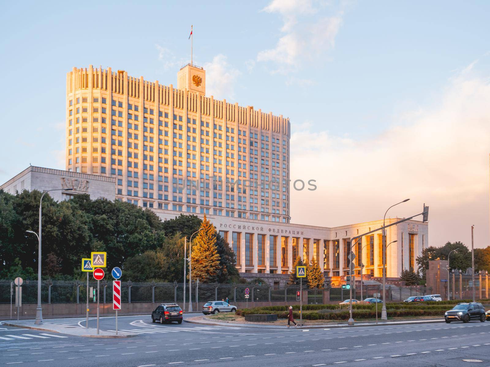 MOSCOW, RUSSIA - September 17, 2022. People go pass the White House, The House of the Government of the Russian Federation. Famous building at autumn sunset. by aksenovko