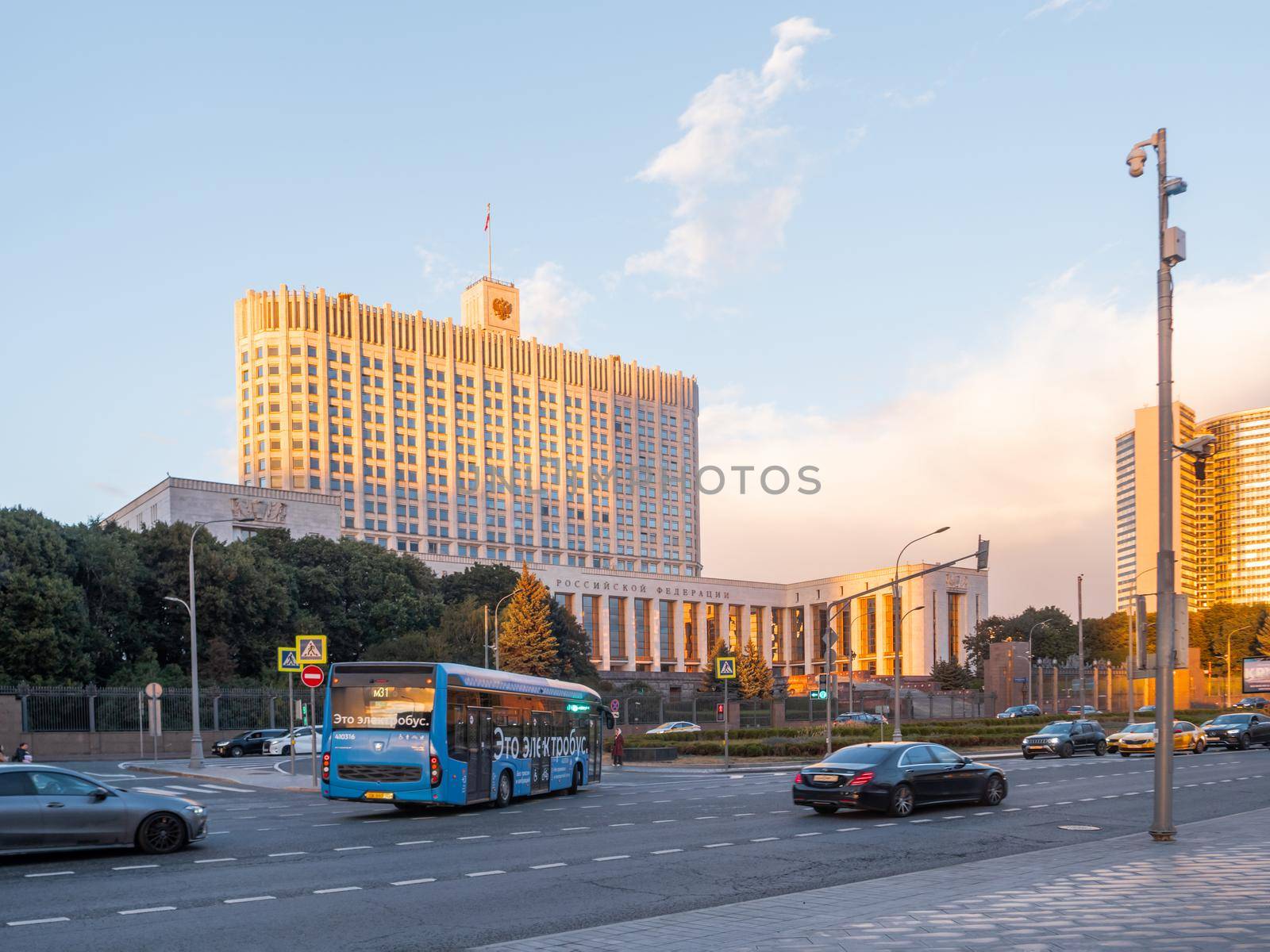 MOSCOW, RUSSIA - September 17, 2022. People go pass the White House, The House of the Government of the Russian Federation. Famous building at autumn sunset. by aksenovko