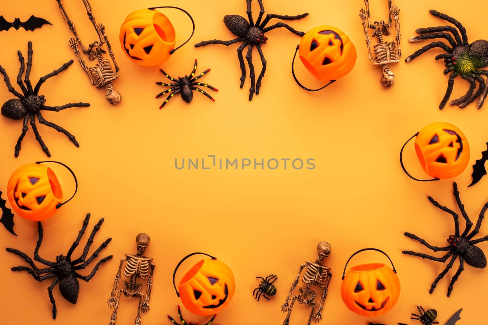 Halloween composition. Halloween decorations, pumpkins, bats, spiders on orange background. Halloween concept. Flat lay, top view, copy space