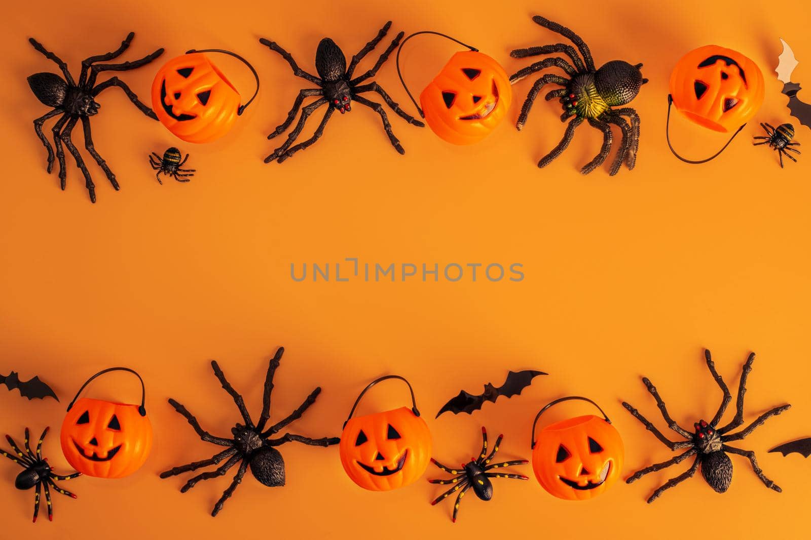 Halloween composition. Halloween decorations, pumpkins, bats, spiders on orange background. Halloween concept. Flat lay, top view, copy space