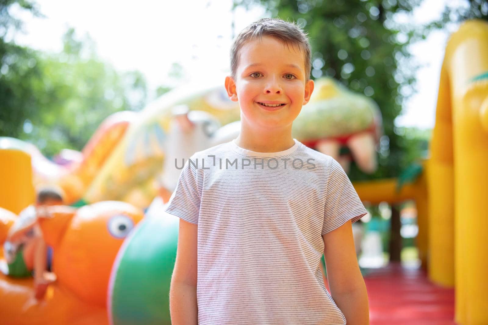 Happy boy having a lots of fun on a colorful inflate castle. Colorful playground. Activity and play center for kids.