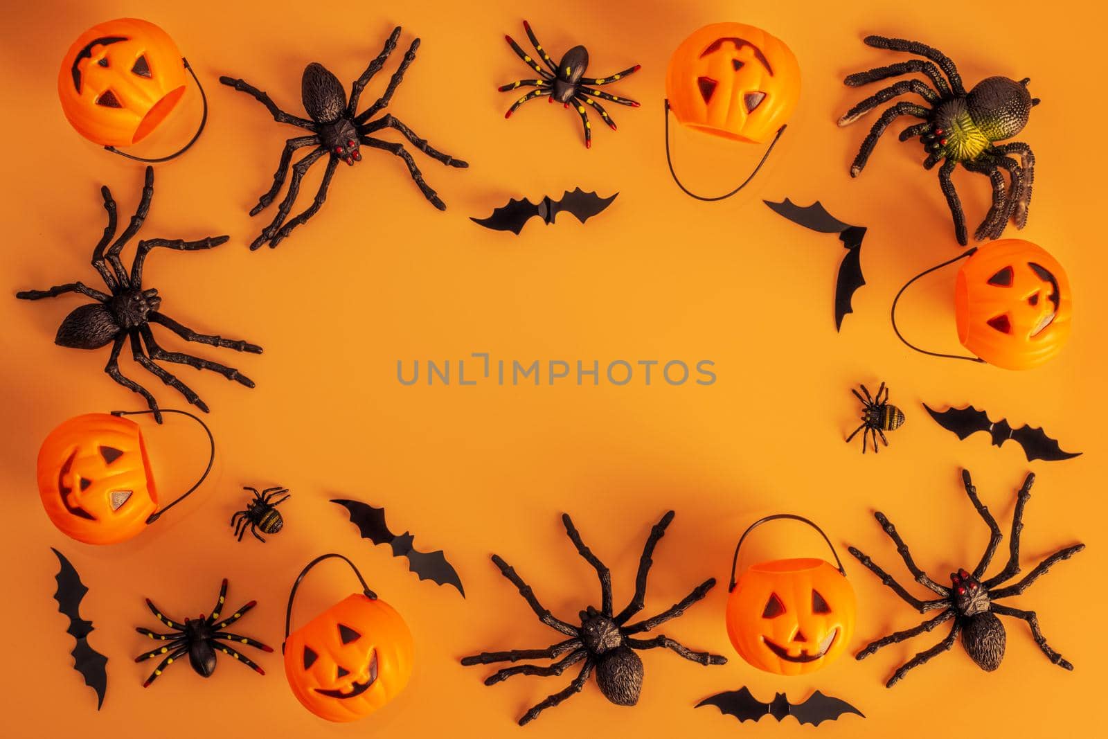 Halloween composition. Halloween decorations, pumpkins, bats, spiders on orange background. Halloween concept. Flat lay, top view, copy space