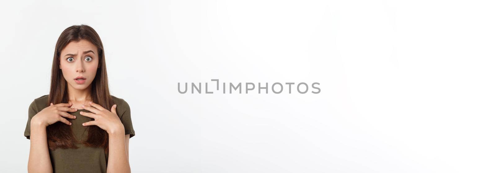 Close-up portrait of surprised beautiful girl holding her head in amazement and open-mouthed. Over white background.