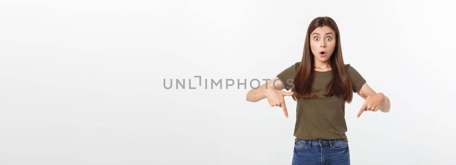 amazement - woman excited looking to the side. Surprised happy young woman looking sideways in excitement. Mixed race Asian and white Caucasian female model on grey background