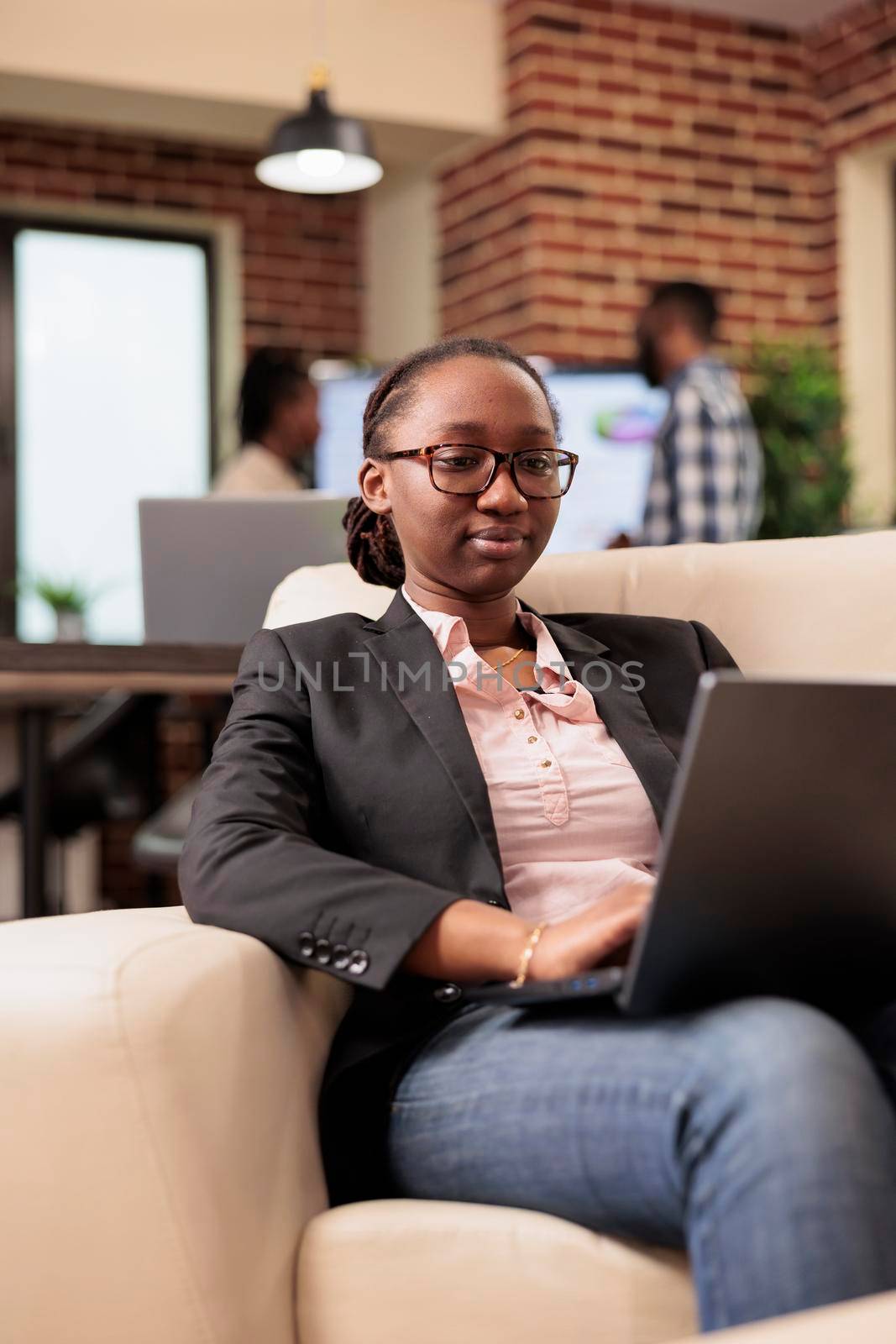 African american project manager analyzing data on laptop, using online research information to create business report. Browsing internet website to work on company management, startup office.