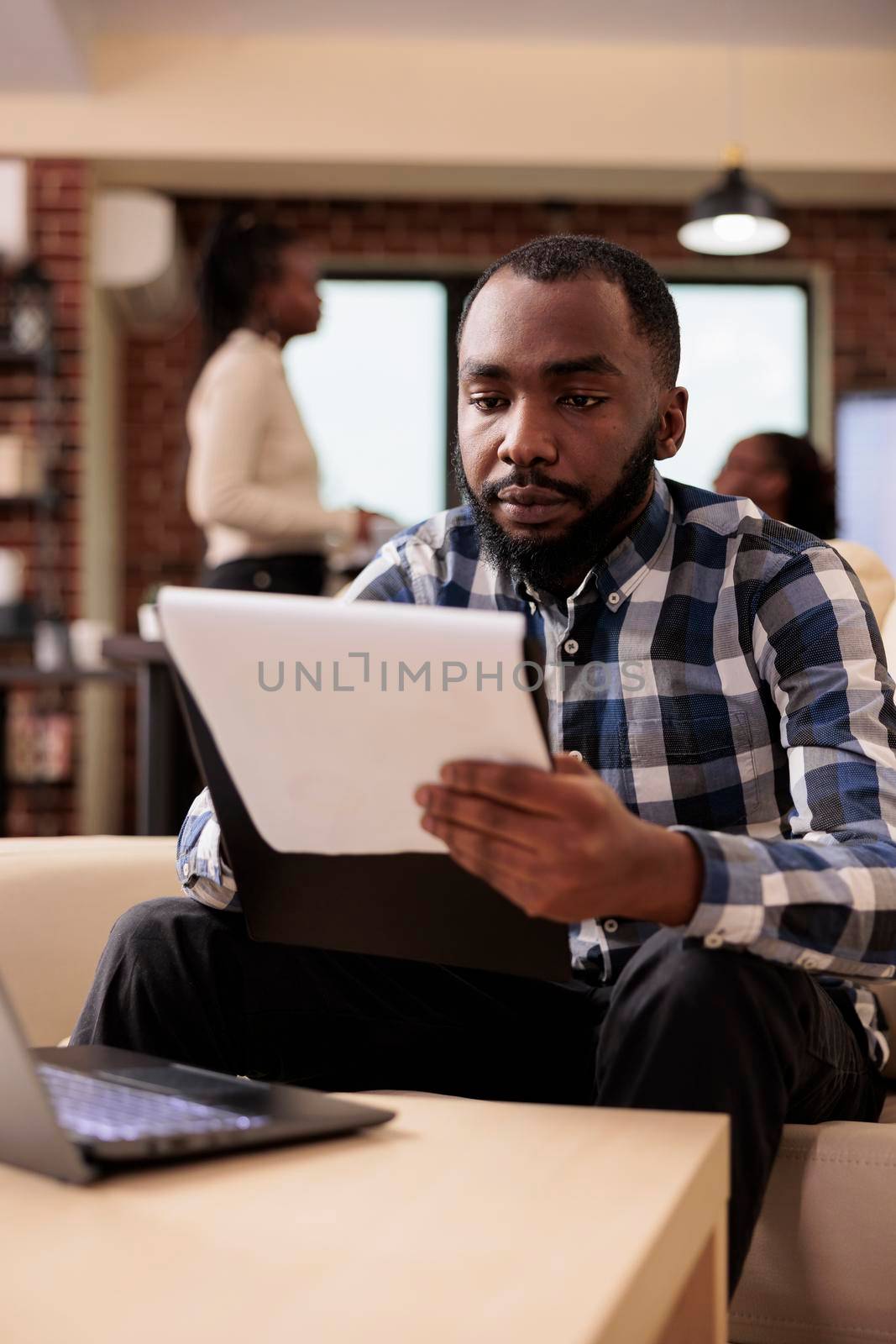 African american businessman doing paperwork by DCStudio