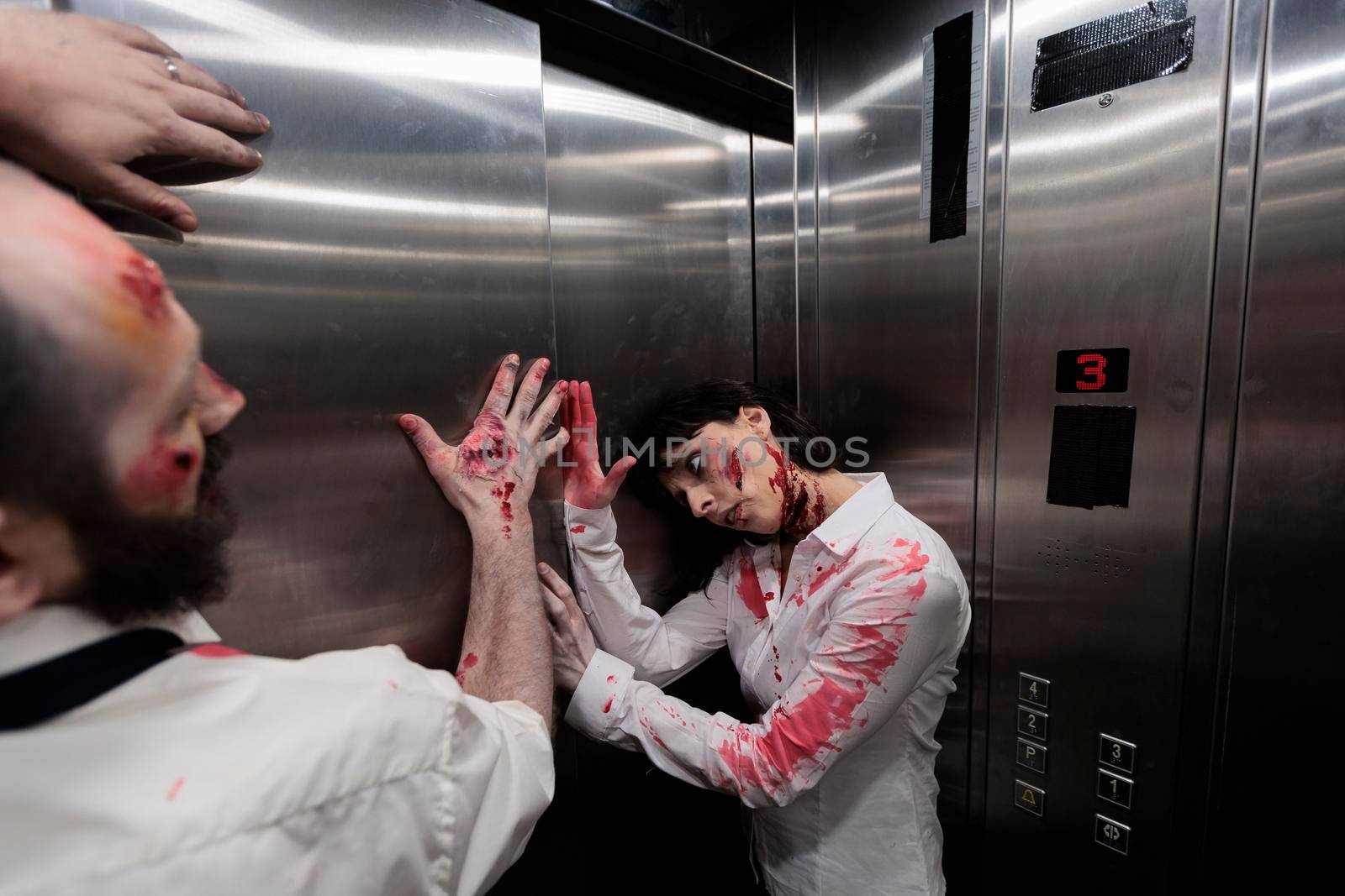 Creepy eerie zombies crawling on elevator walls, preparing terrifying sinister attack in company office. Brain eating walking dead killers looking aggressive and dangerous with bloody scars.