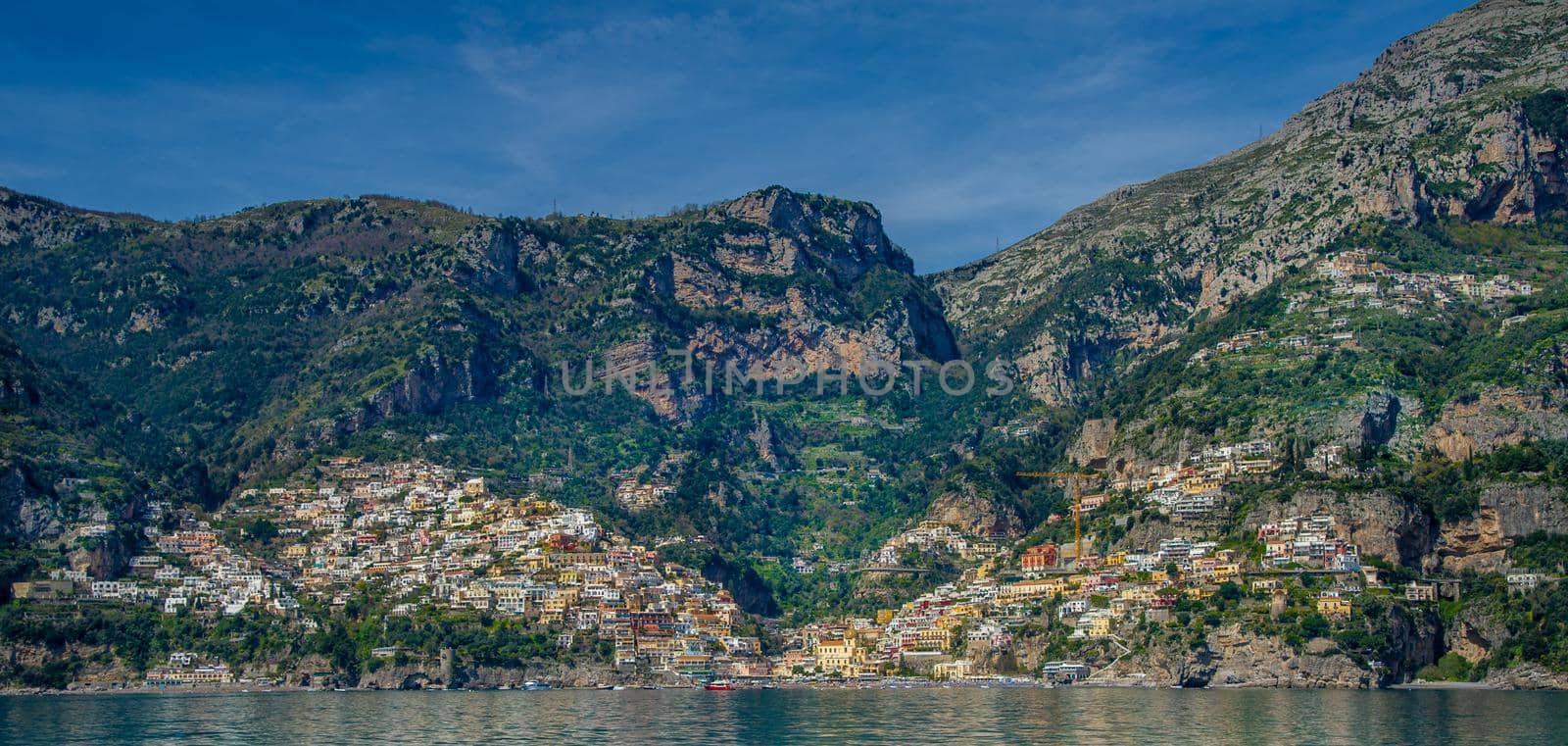 Amalfi Coast Italy photographed from the ferryboat on a sunny day with colourful houses visible on the coast 2022 april 15