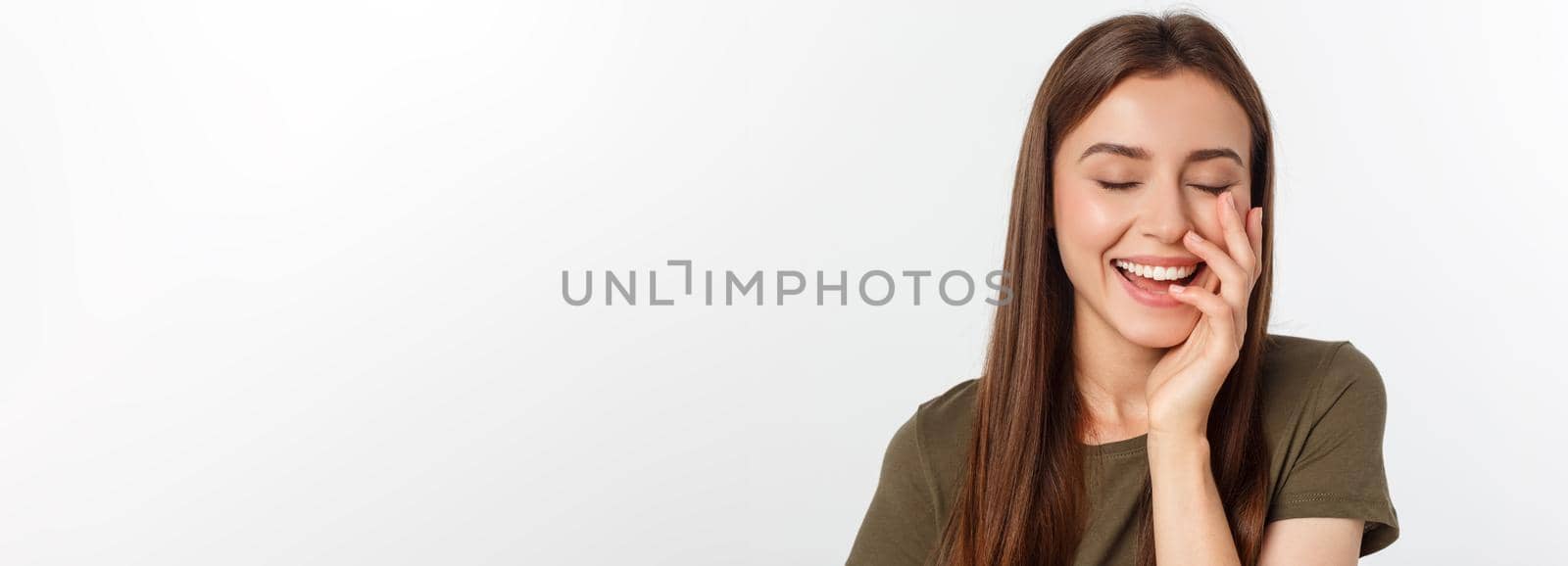 amazement - woman excited looking to the side. Surprised happy young woman looking sideways in excitement. Mixed race Asian and white Caucasian female model on grey background