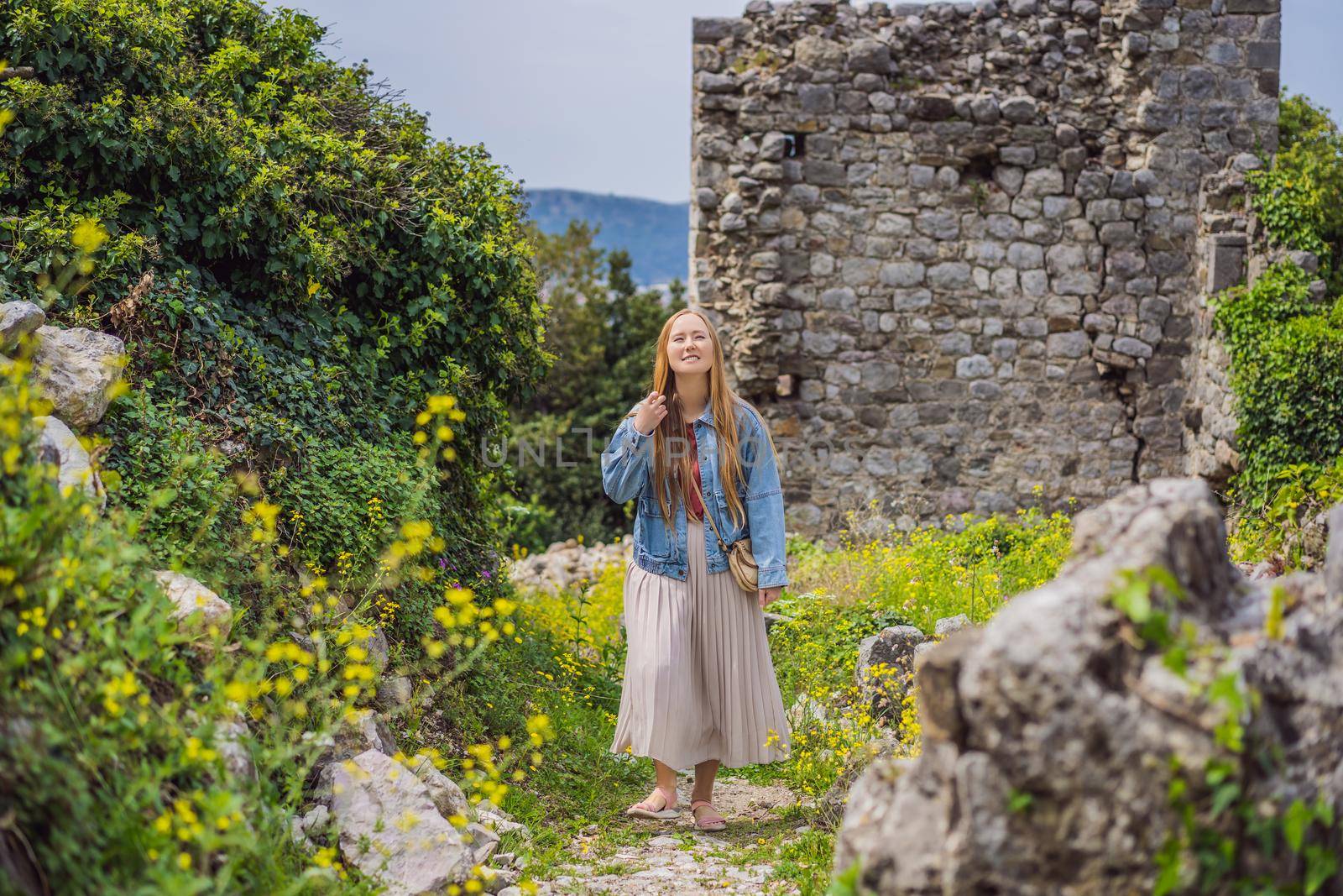 Woman tourist walks through the old town of Bar in Montenegro. Happy tourist walks in the mountains. Suburbs of the city of Bar, Montenegro, Balkans. Beautiful nature and landscape.