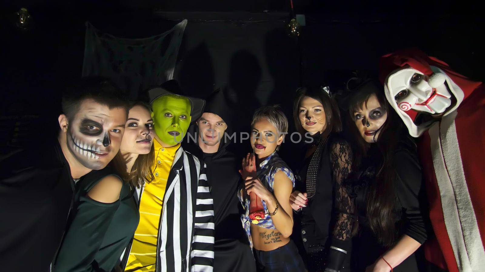 Halloween party, night, twilight, in the rays of light, young people frighten the spectators, everyone is dressed in scary costumes for Halloween. High quality photo