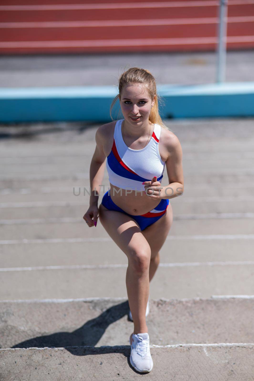 Young caucasian woman running on stadium stairs outdoors