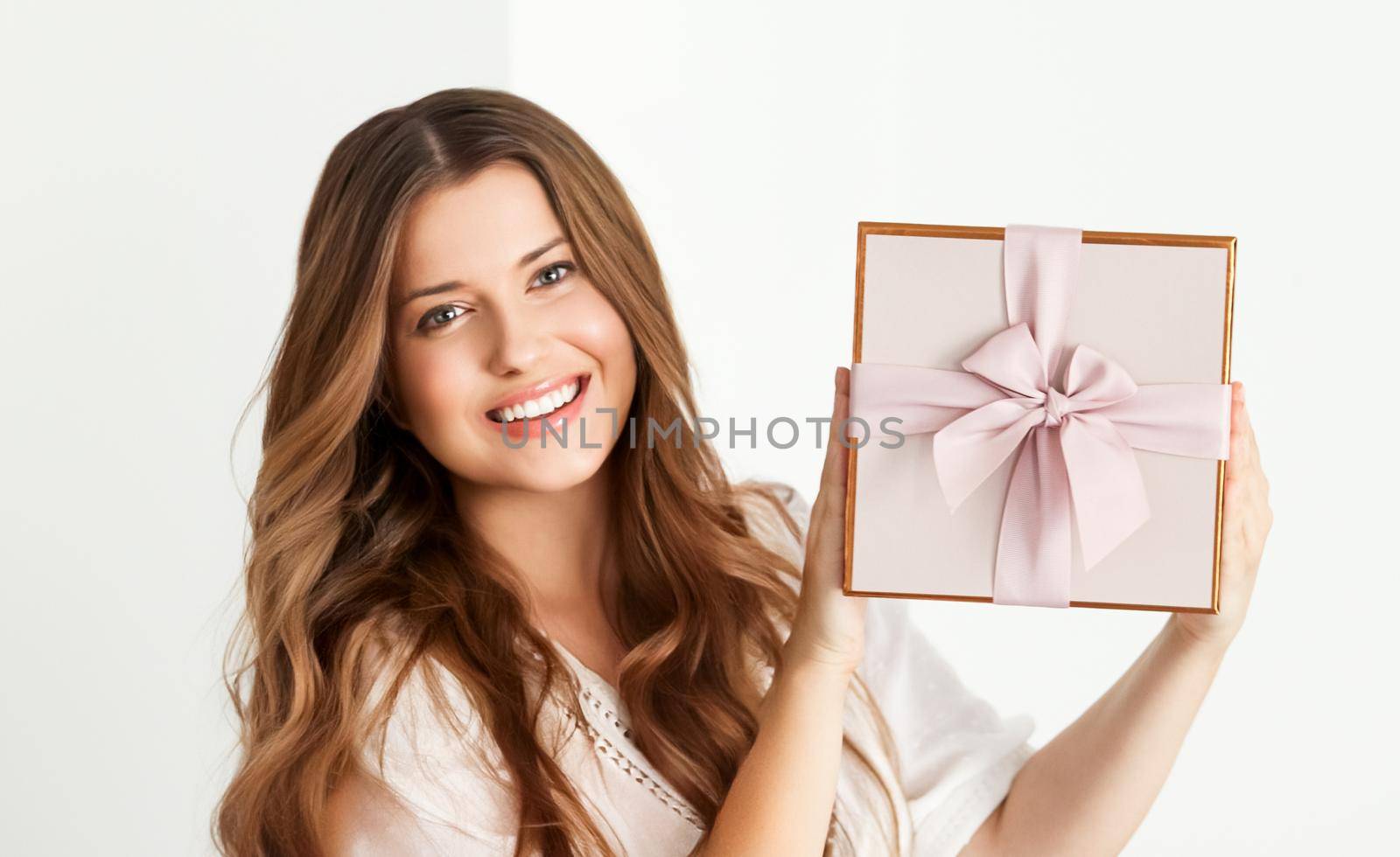 Holiday present for birthday, baby shower, wedding or luxury beauty box subscription delivery, happy woman holding a wrapped pink gift on white background