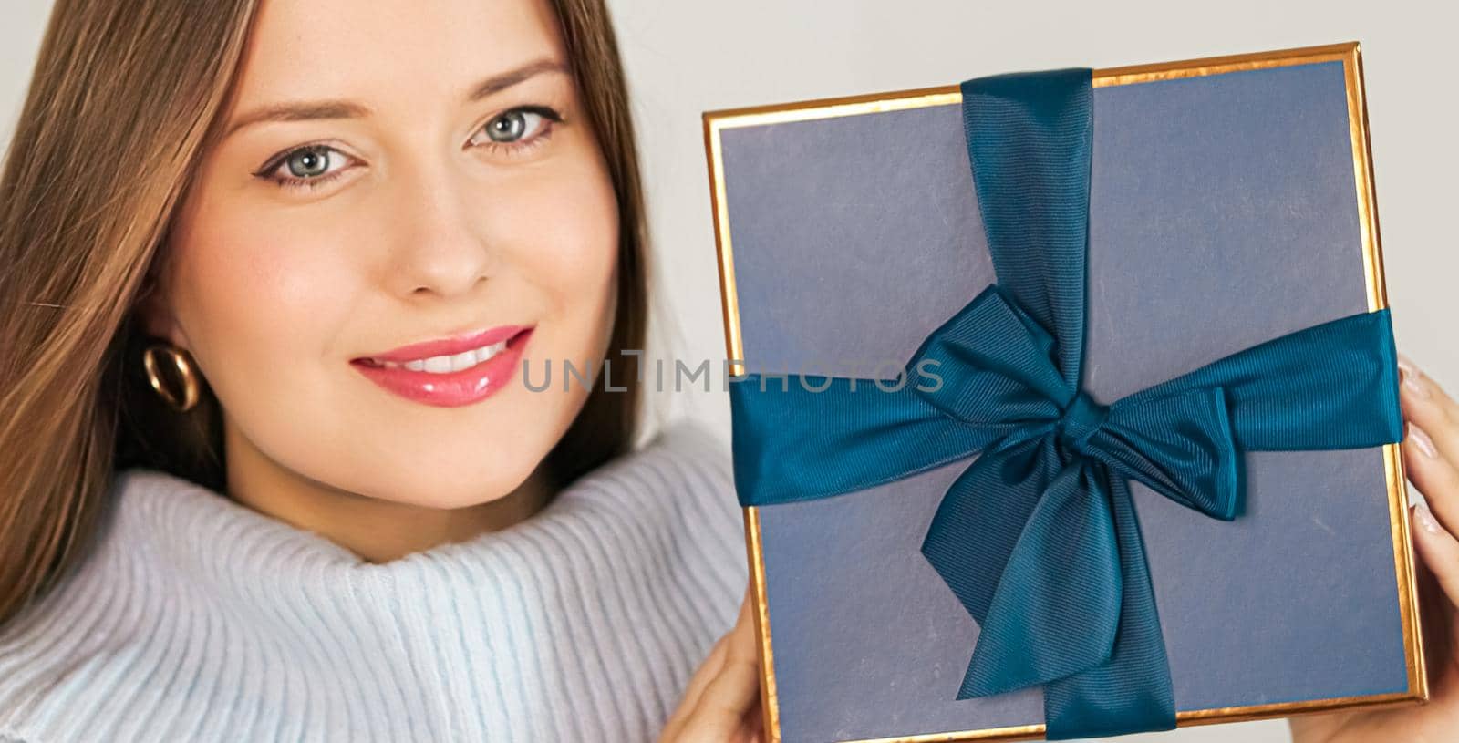 Winter holidays, present and Merry Christmas concept, happy woman smiling and holding wrapped gift box, close-up portrait