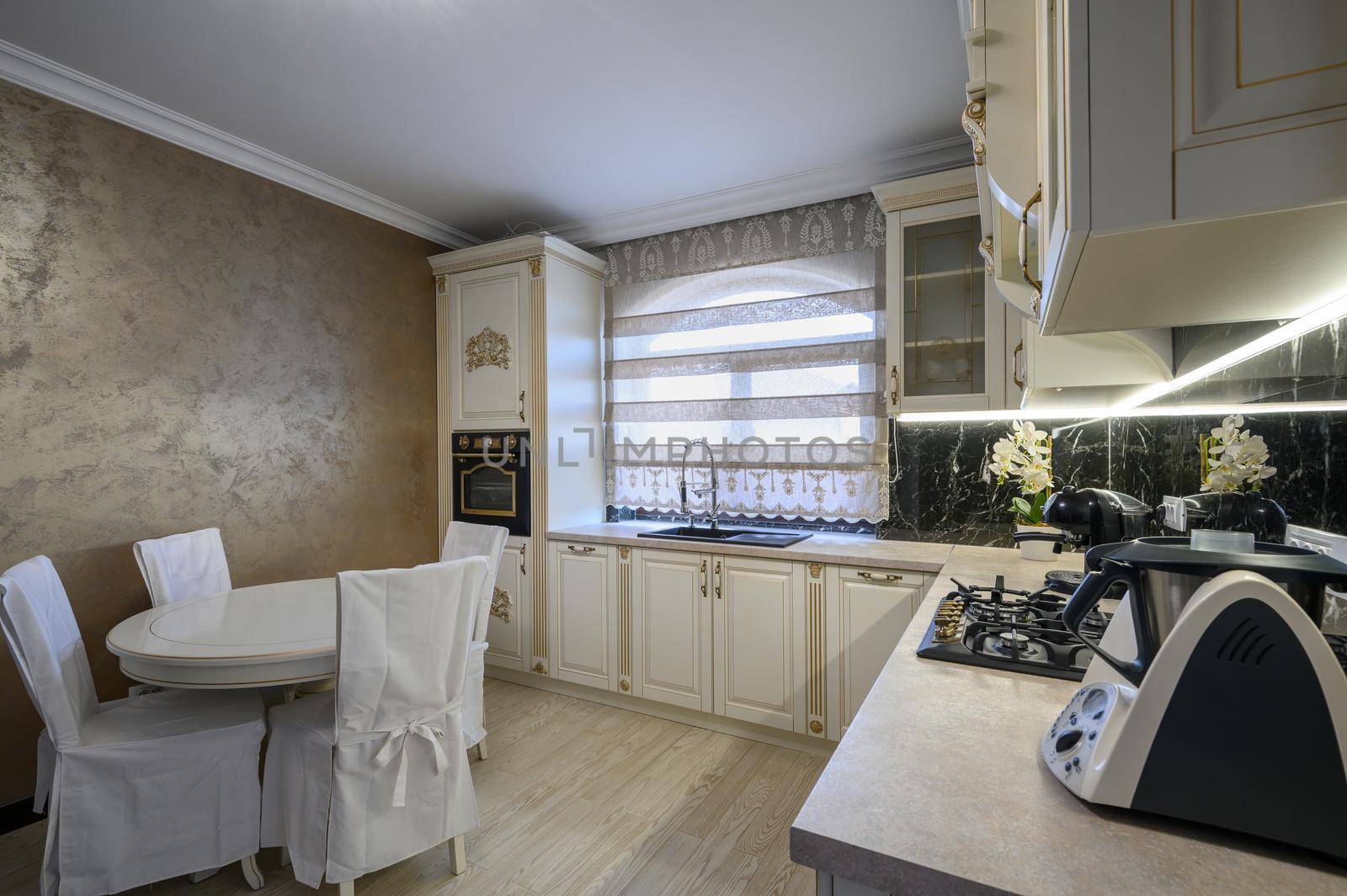 White rich classic cozy kitchen and dining room in city house interior