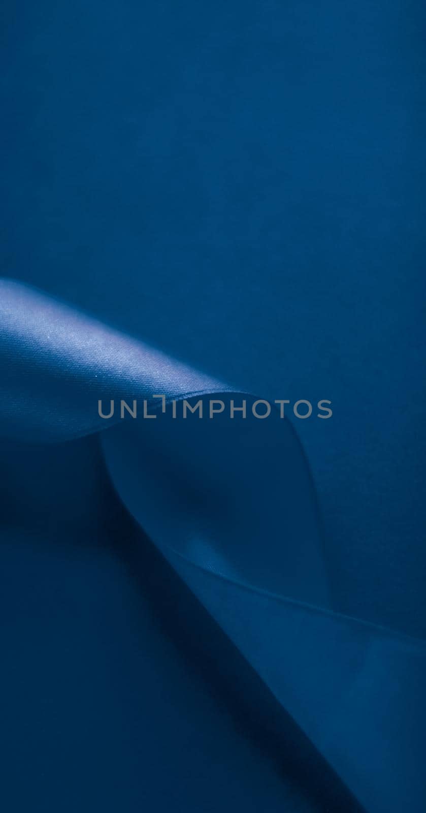 Branding, holidays and luxe brands concept - Abstract silk ribbon on royal blue background, exclusive luxury brand design for holiday sale product promotion and glamour art invitation card backdrop