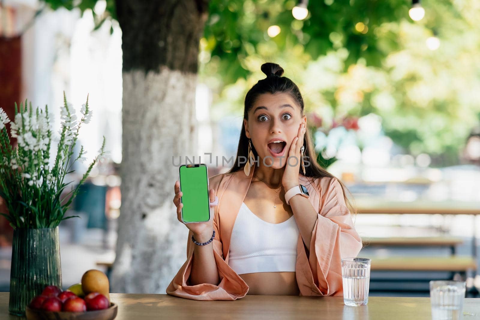 Happy woman hold smartphone. Green screen phone screen