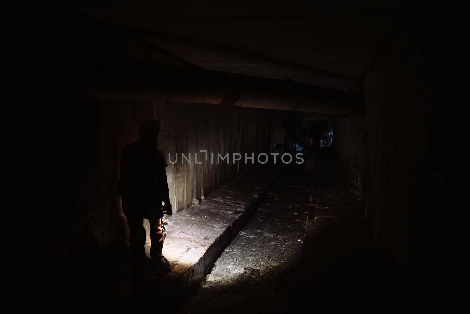 A young female digger with a flashlight explores the tunnel
