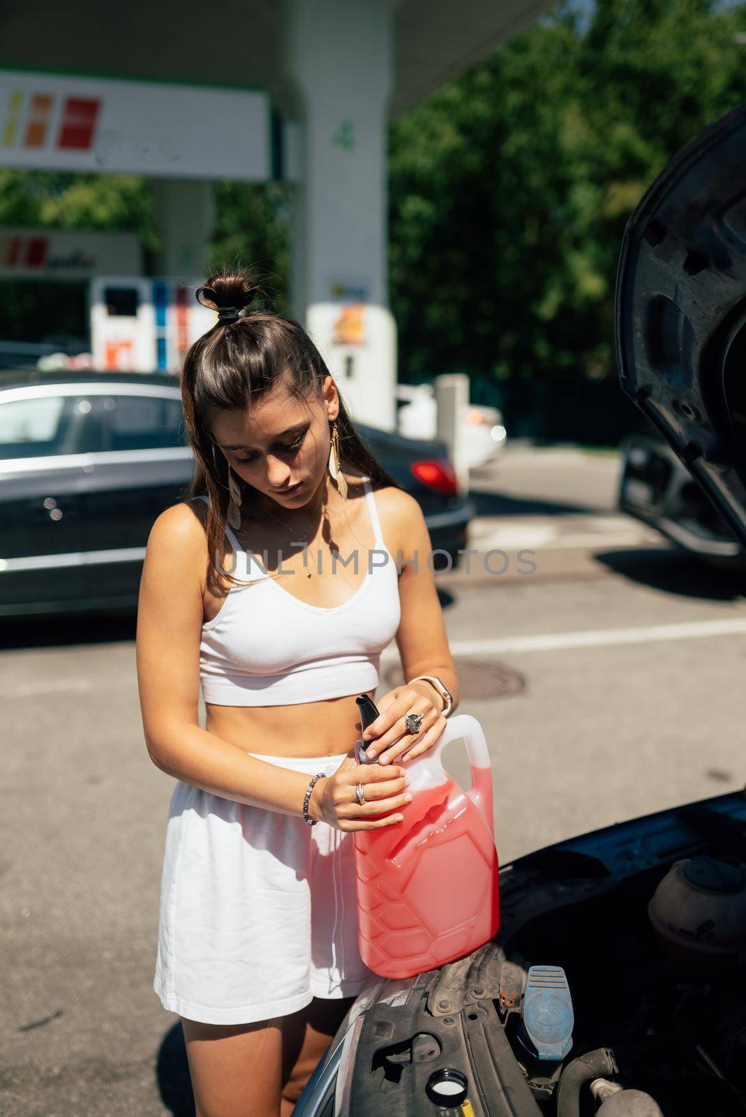 Woman opens container with antifreeze for windshield washer