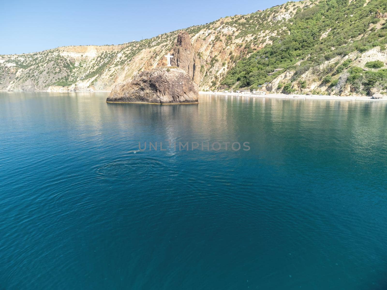 Sea landscape with rocky coastline on sunset time with cloudy sky. Yachts in the Sea on a background of rocky shores. The concept of perfect place for summer travel and rest.