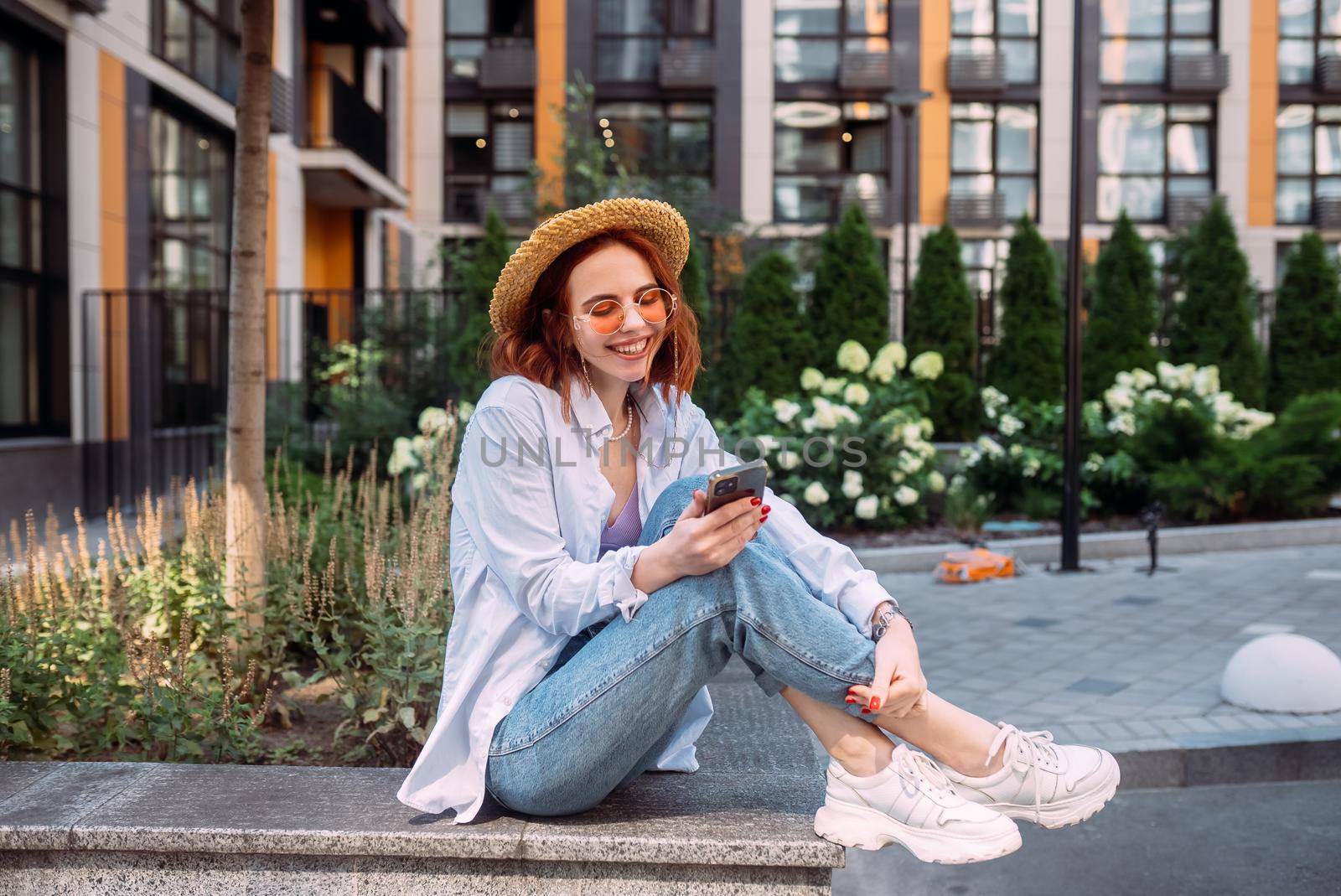 Photo of cute adorable young lady sitting stairs typing modern device outside urban city street