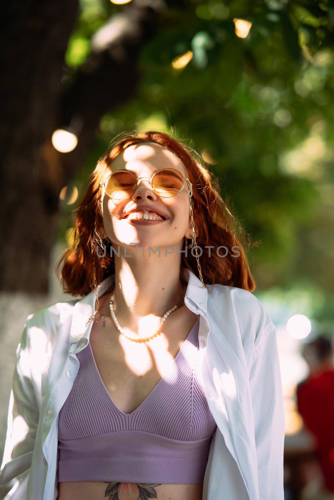 Close up portrait of a young caucasian woman with ginger red hair and toothy smile in outdoors