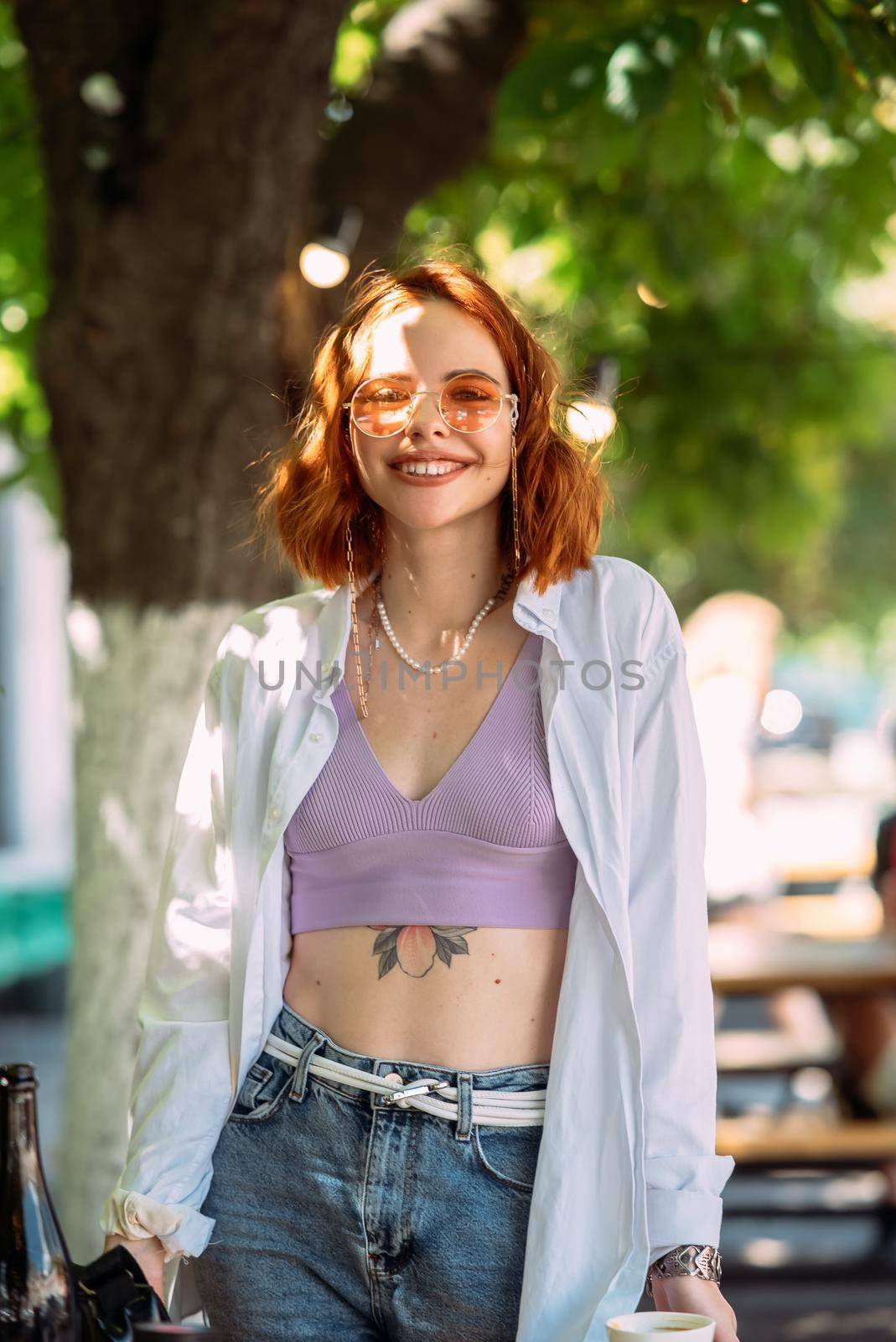 Close up portrait of a young caucasian woman with ginger red hair and toothy smile in outdoors
