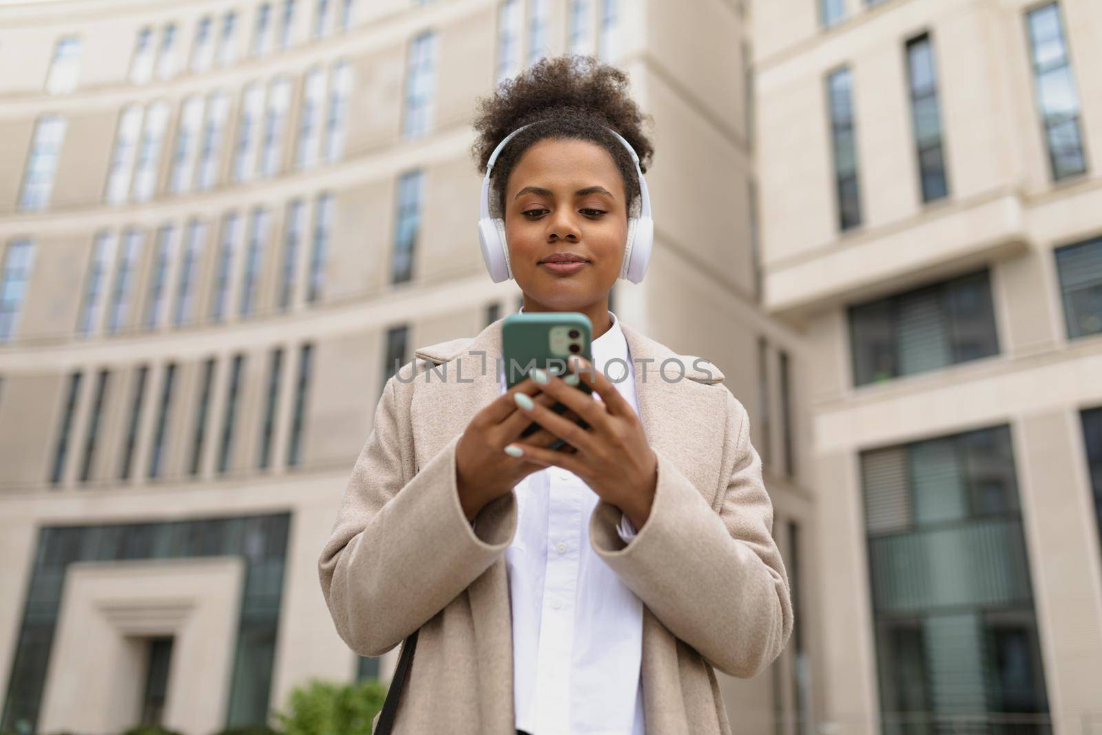 african american woman Expert of an insurance company with a mobile phone against the background of a business center by TRMK