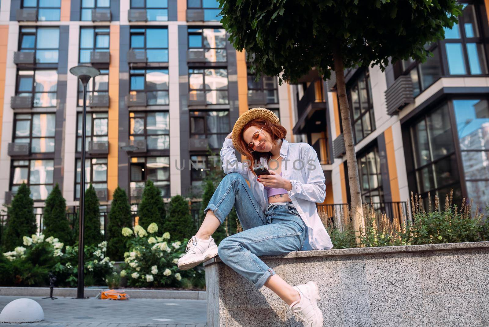 Photo of cute adorable young lady sitting stairs typing modern device outside urban city street