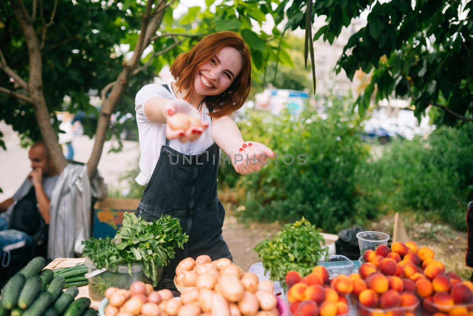 Woman seller at the counter with vegetables.