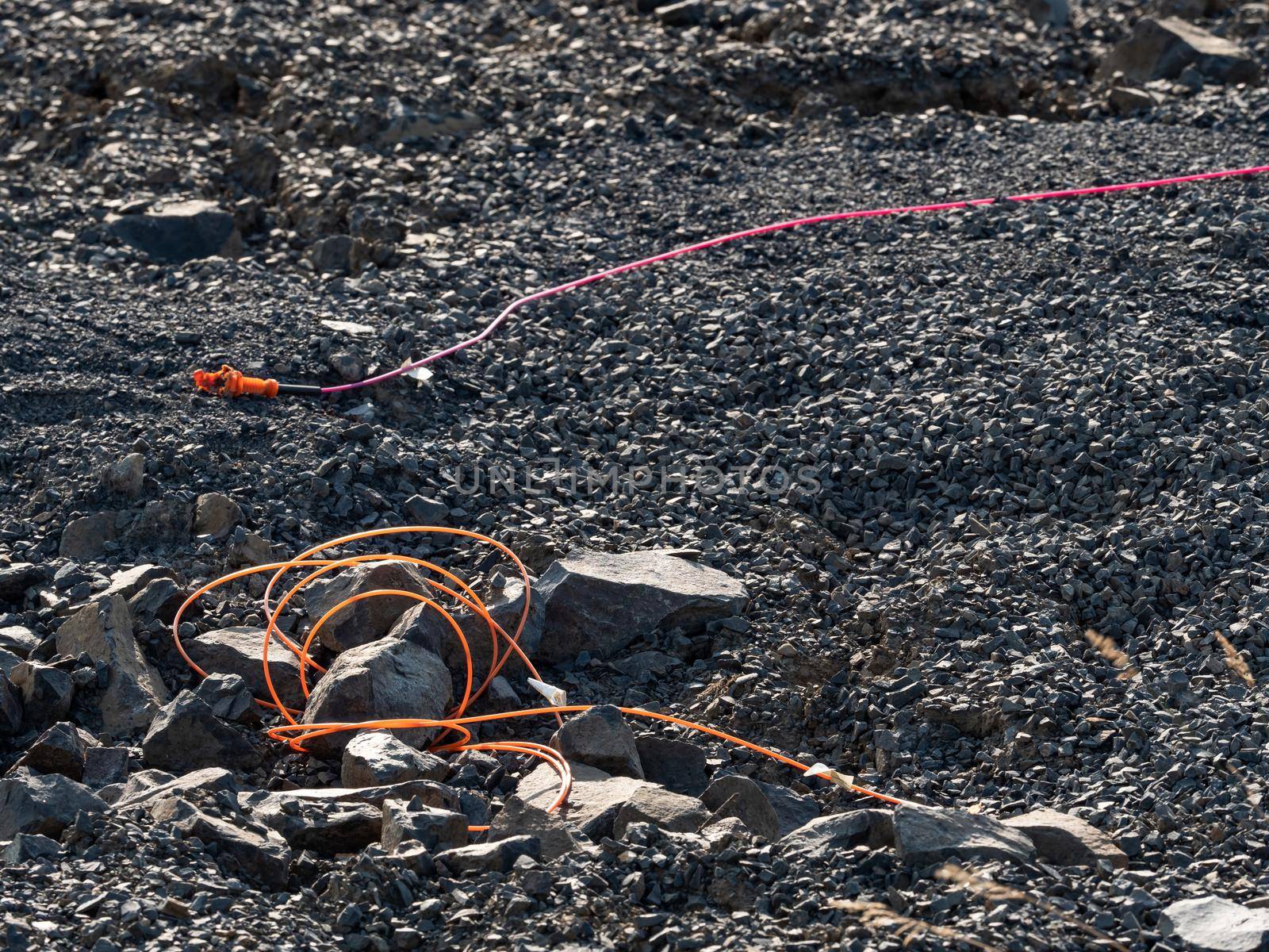 Explosive works in quarry , drilled rocks stuffed with explosives and colorful ignition lines. Holes for explosive filing in basalt mine