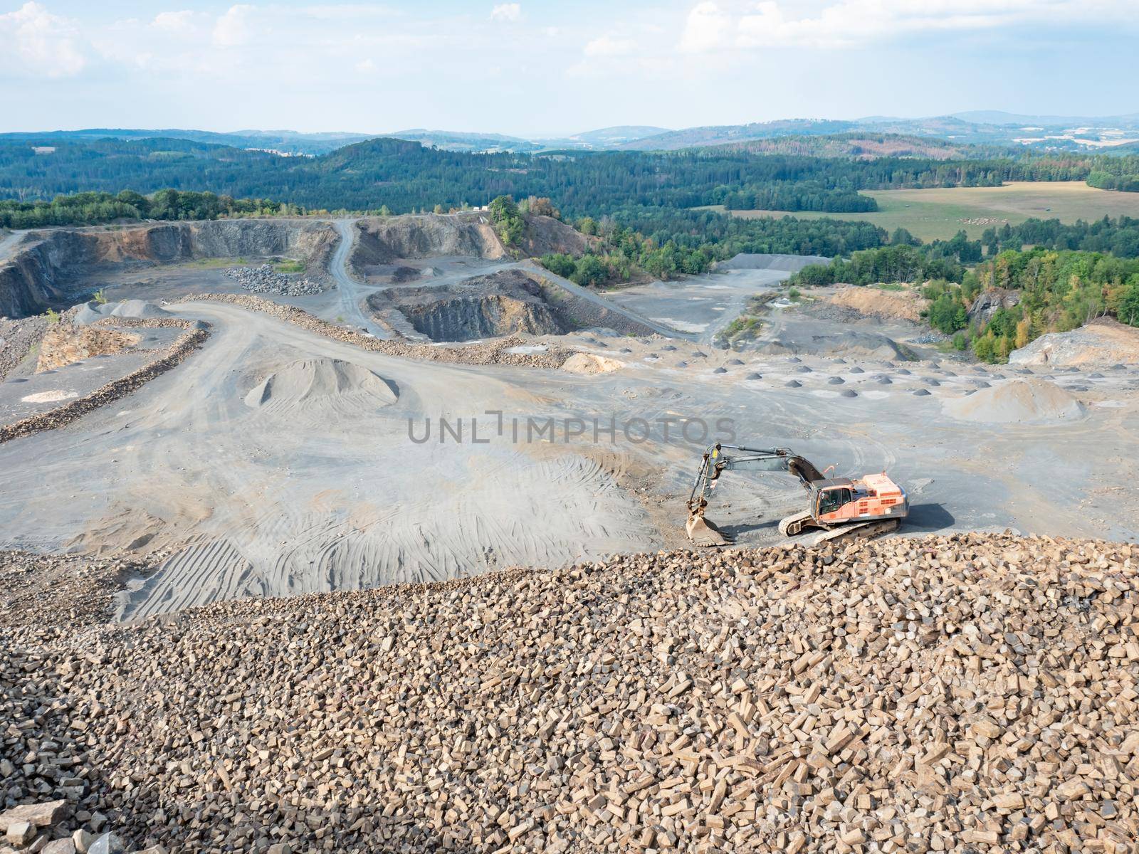 Old worn out loader between piles of crushed basalt stones.  by rdonar2