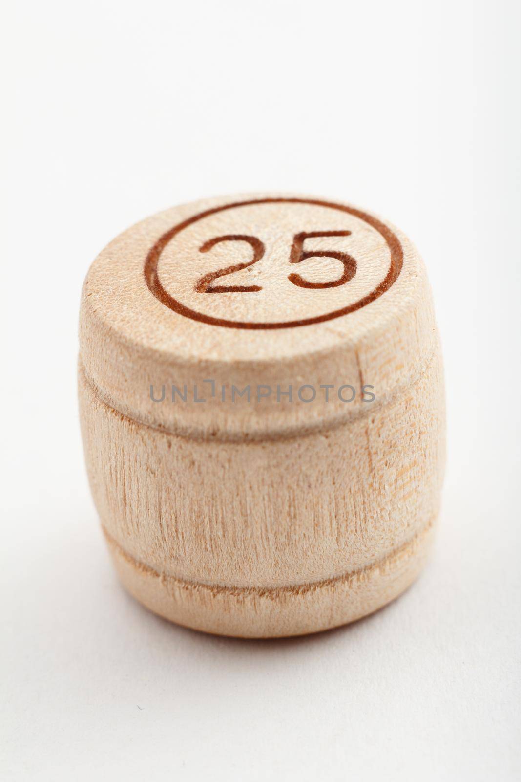 Wooden barrel number for a lotto game on a white background. Close-up view