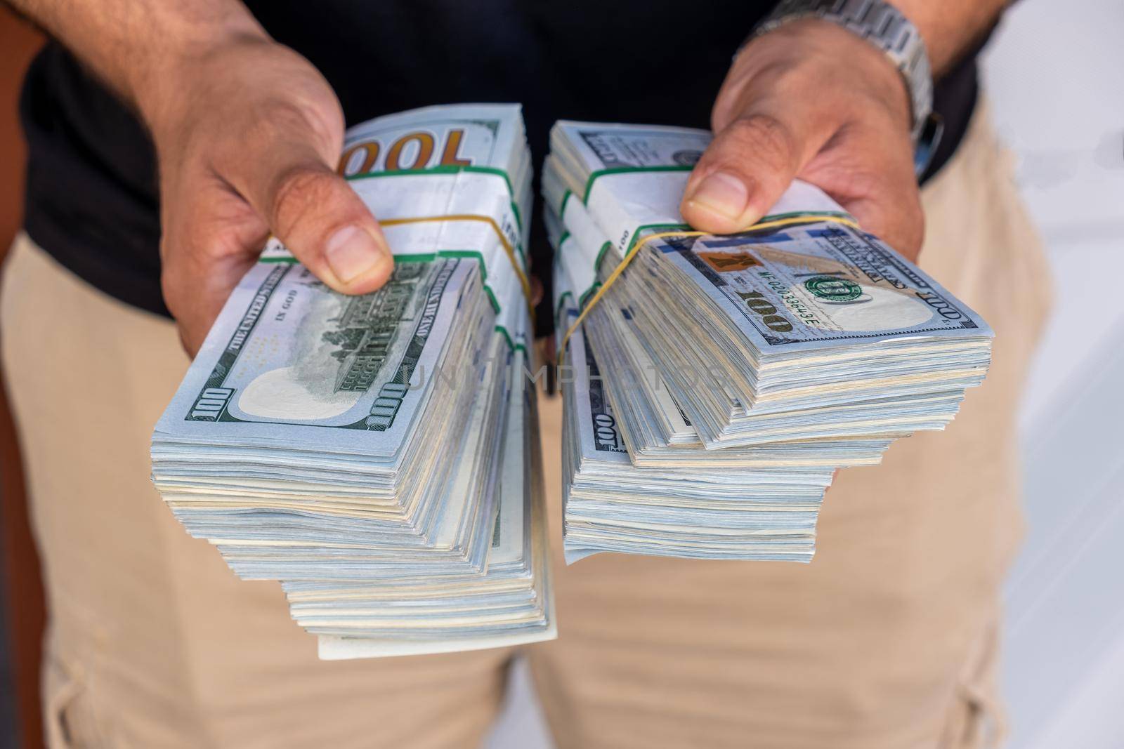 Bundles of US dollars in the hands of businessman. Selective focus