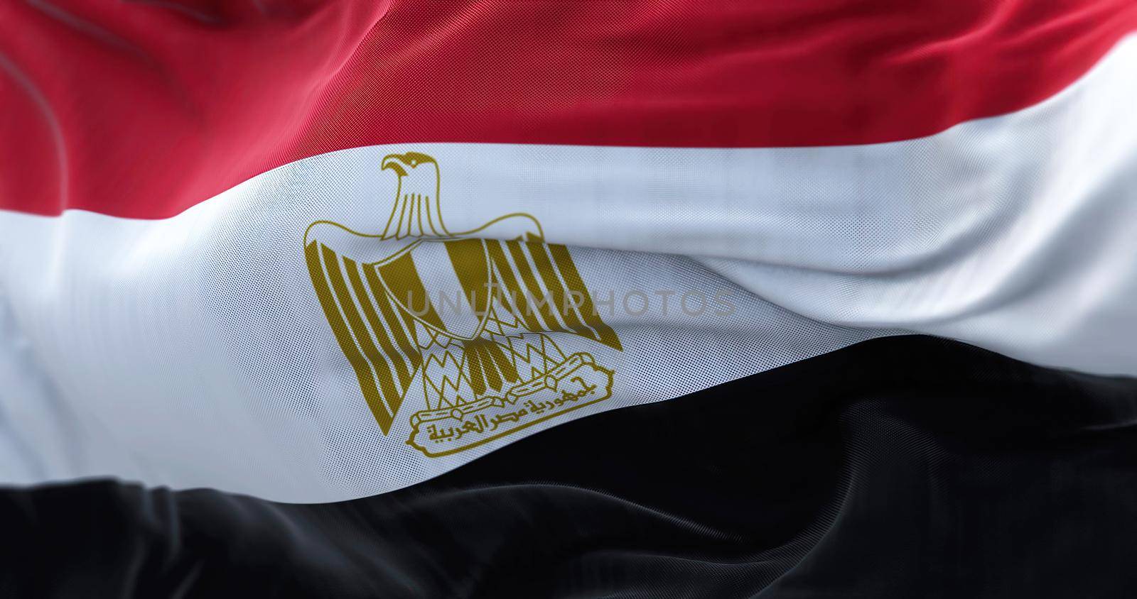 Close-up view of the Egypt national flag waving in the wind. The Arab Republic of Egypt is a country located in the northeast corner of Africa. Fabric textured background. Selective focus