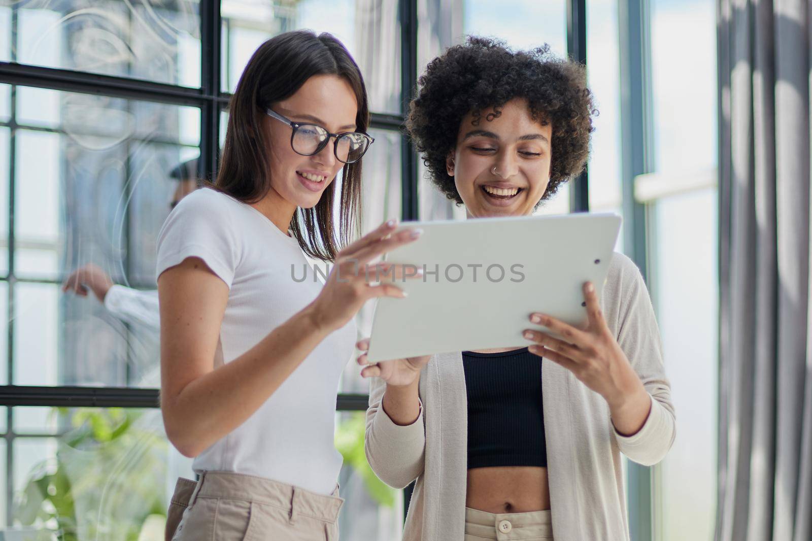 Two women analyzing documents office. Woman executives at work in office discussing some paperwork. by Prosto