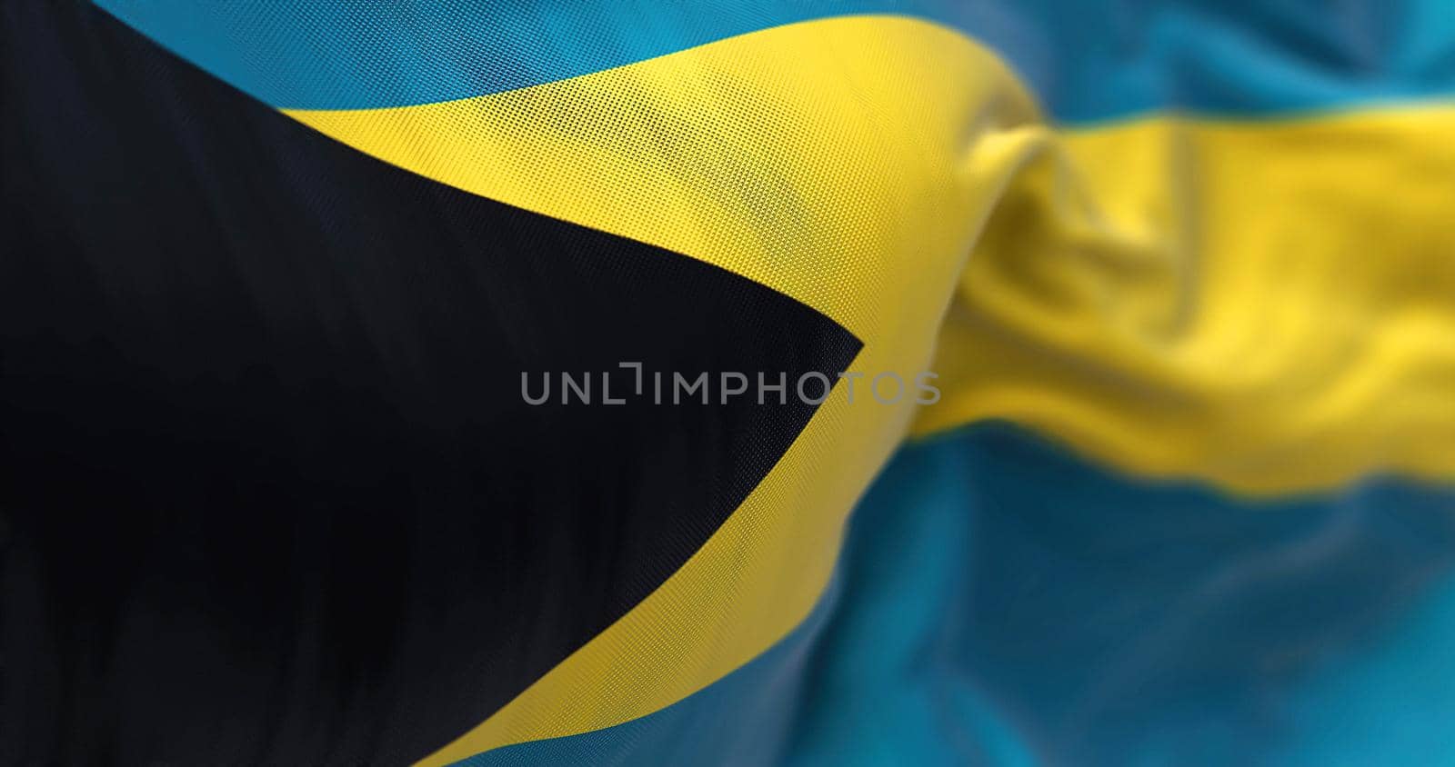 Close-up view of the Bahamas national flag waving in the wind. The Commonwealth of the Bahamas is a country within the Lucayan Archipelago. Fabric textured background. Selective focus