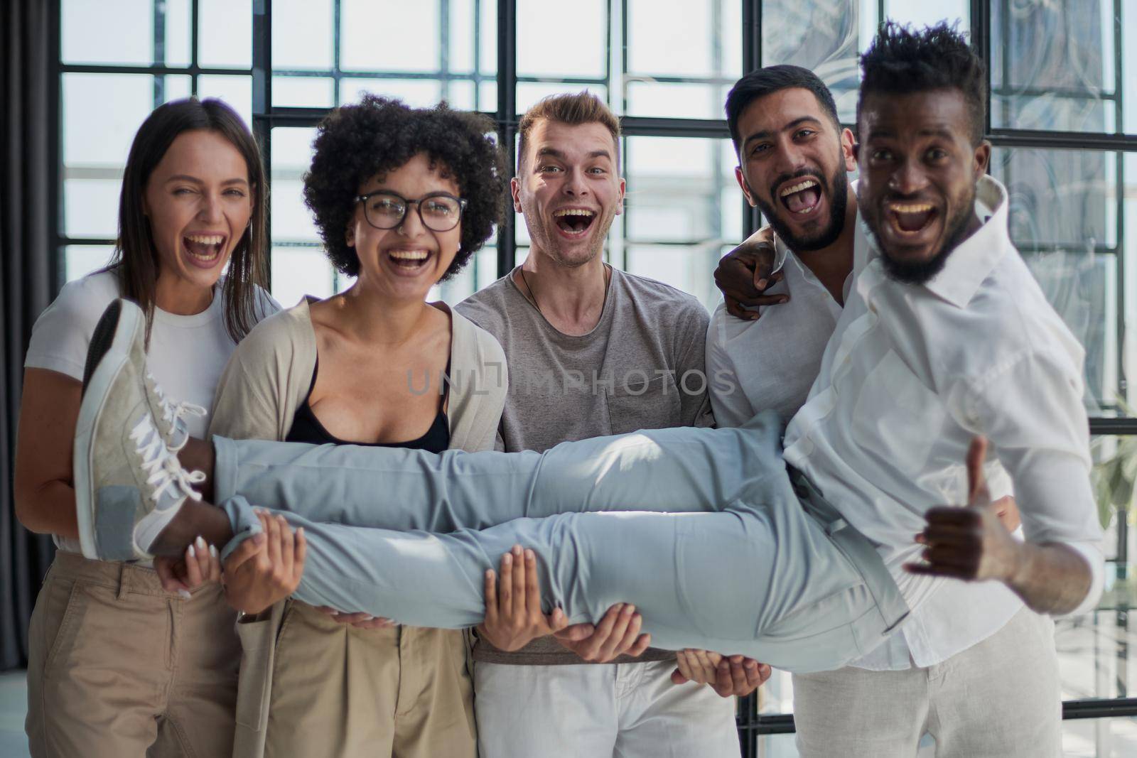 Business team throwing his colleague in office by Prosto